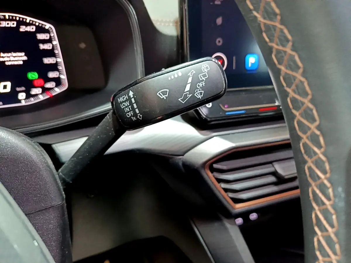 Gros plan sur la commande d’essuie-glace à gauche du volant cuir gris avec surpiqûres marron dans le CUPRA Formentor 2024.