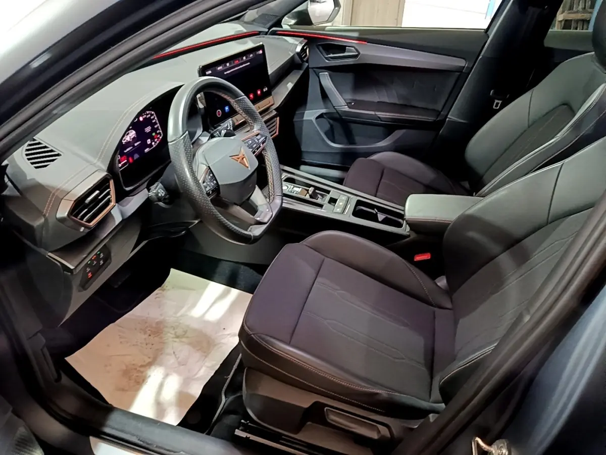 Vue intérieure côté conducteur du CUPRA Formentor 2024 gris foncé, volant multifonctions cuir alu et écran tactile central.