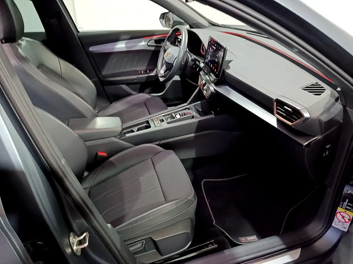 Vue intérieure côté conducteur de la CUPRA Formentor 1.5 TSI 2024, sièges noirs et tableau de bord moderne avec écran tactile.