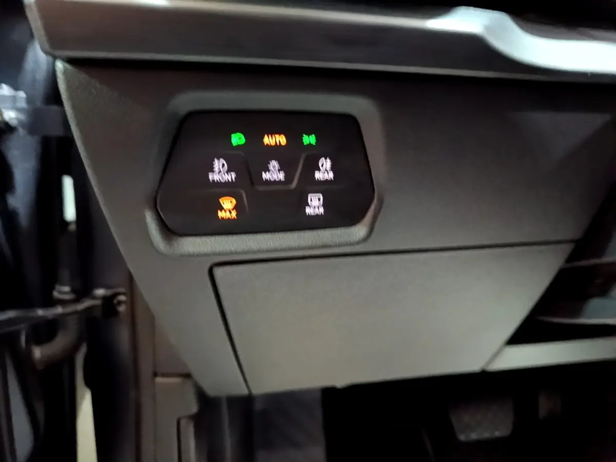 Gros plan sur les commandes d’éclairage et de désembuage sous le tableau de bord d’un CUPRA Formentor gris foncé.