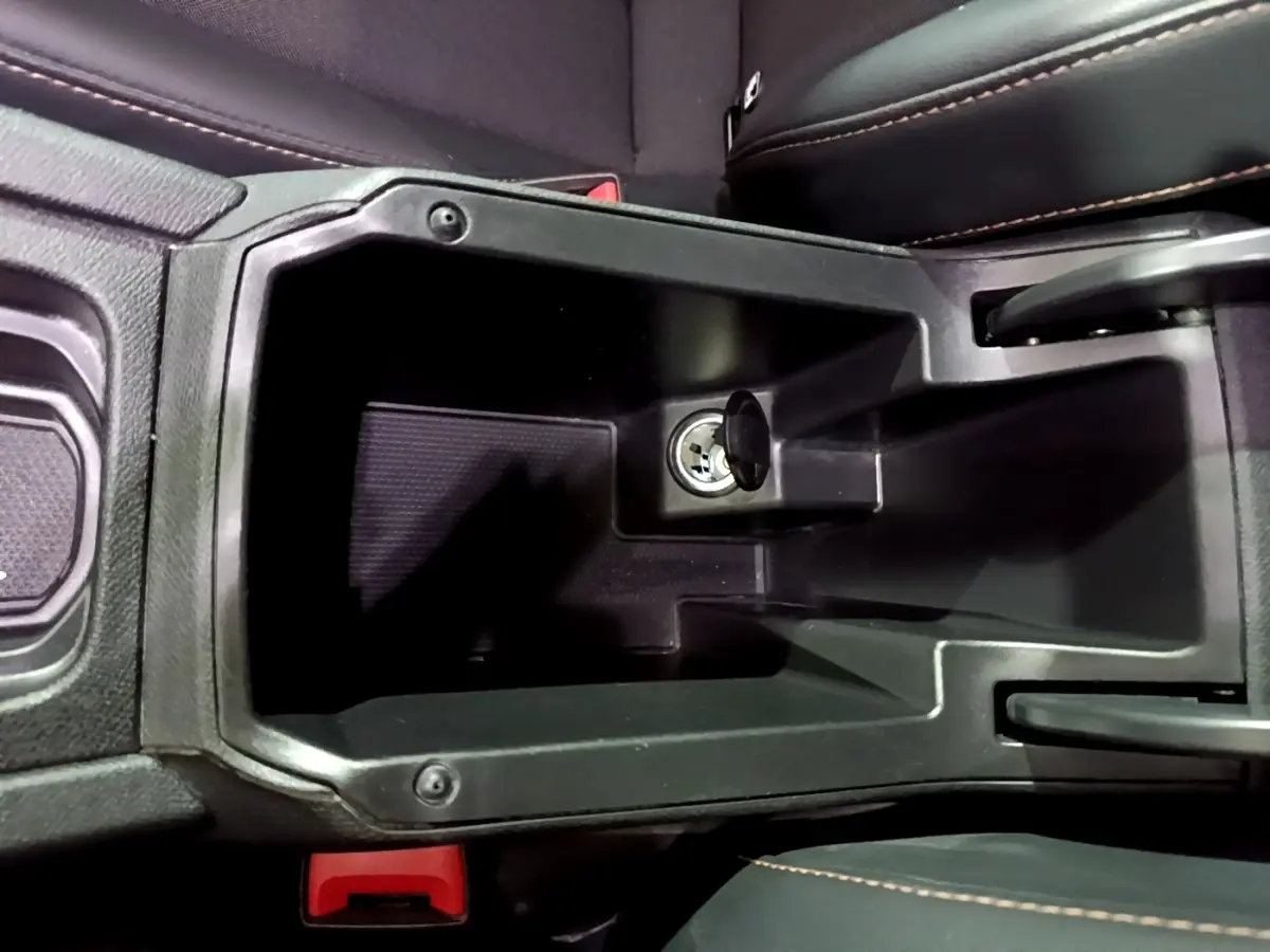 Vue plongeante sur le rangement central noir avec prise 12V du CUPRA Formentor gris foncé, intérieur cuir noir.