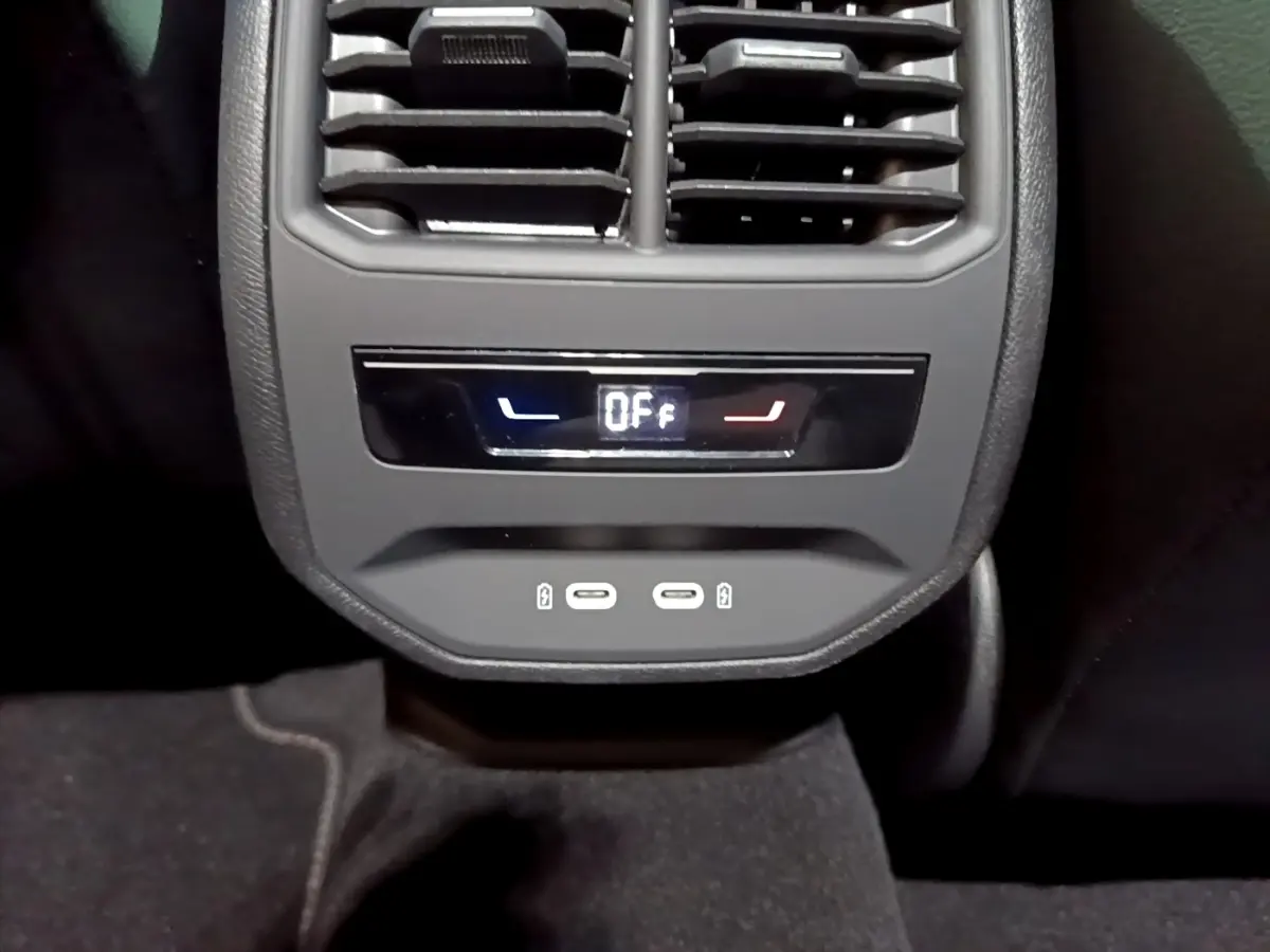 Vue rapprochée de la console arrière du CUPRA Formentor gris foncé, avec commandes climatisation et ports USB visibles.
