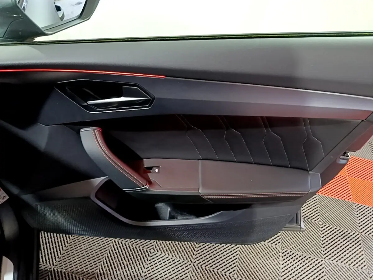 Vue rapprochée de la porte côté gauche de la CUPRA Formentor 2024, avec garniture noire et surpiqûres rouges.