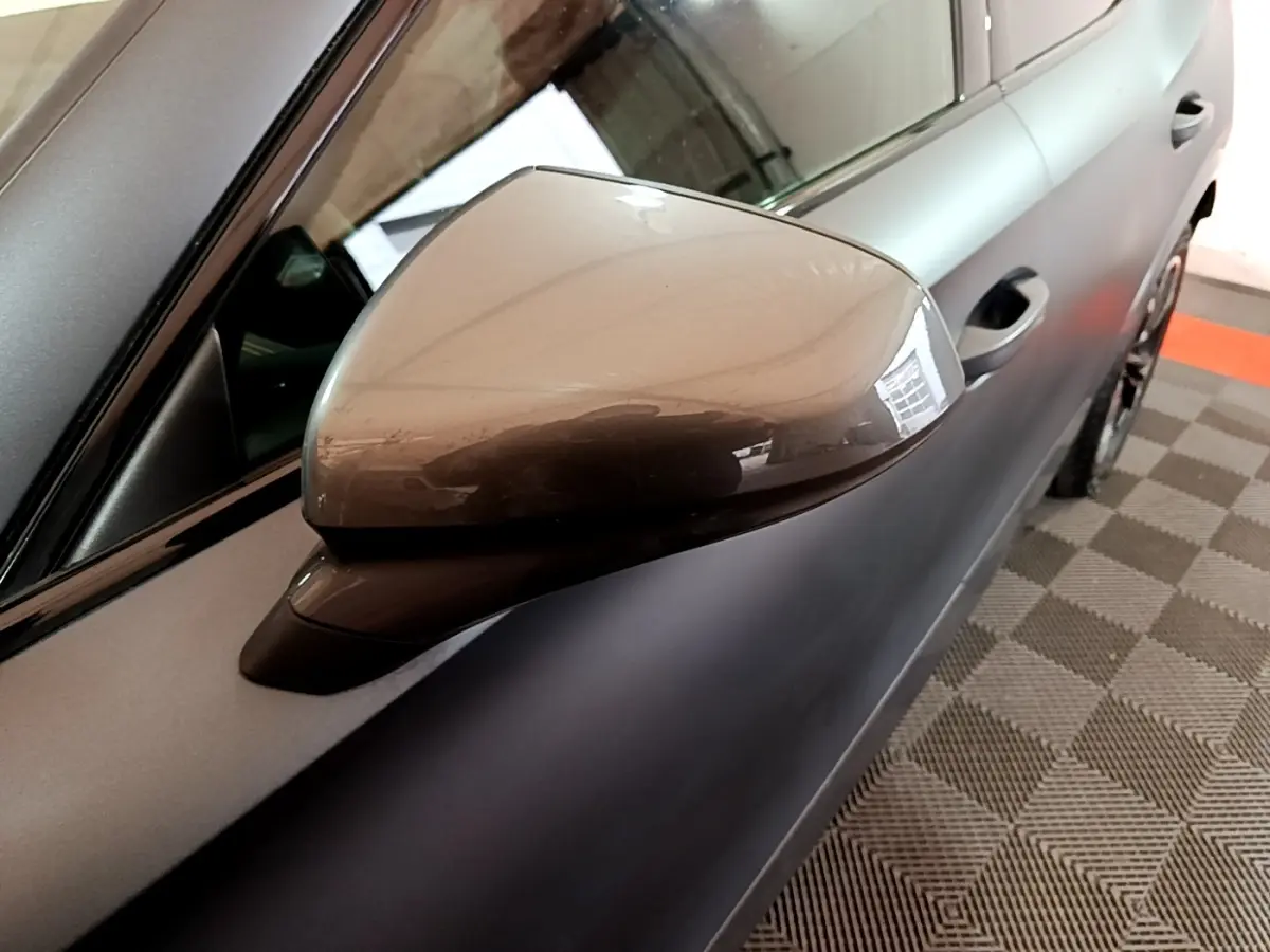 Gros plan sur le rétroviseur droit gris foncé du CUPRA Formentor 2024, avec partie de la porte visible en arrière-plan.