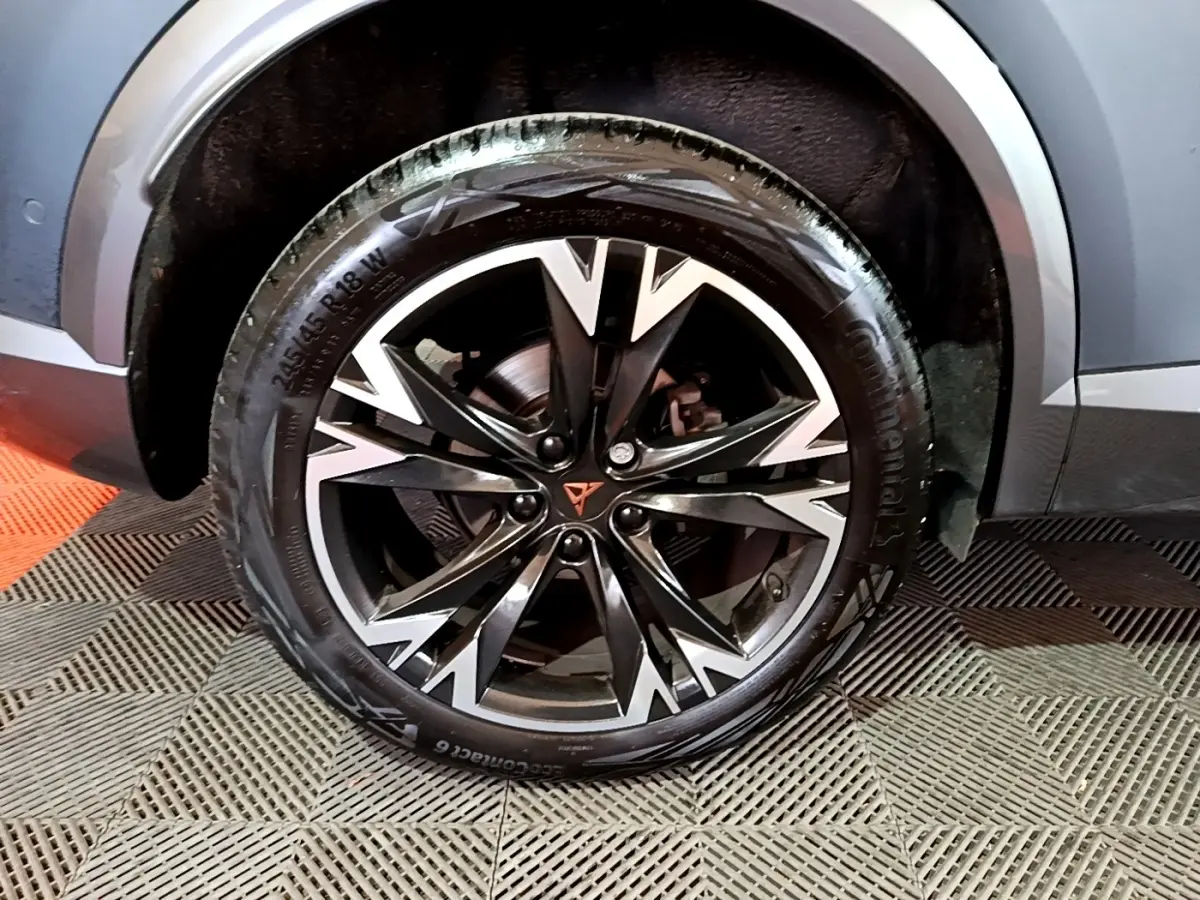 Gros plan sur la roue avant droite du CUPRA Formentor gris foncé avec jante alliage noire et argentée au design anguleux.