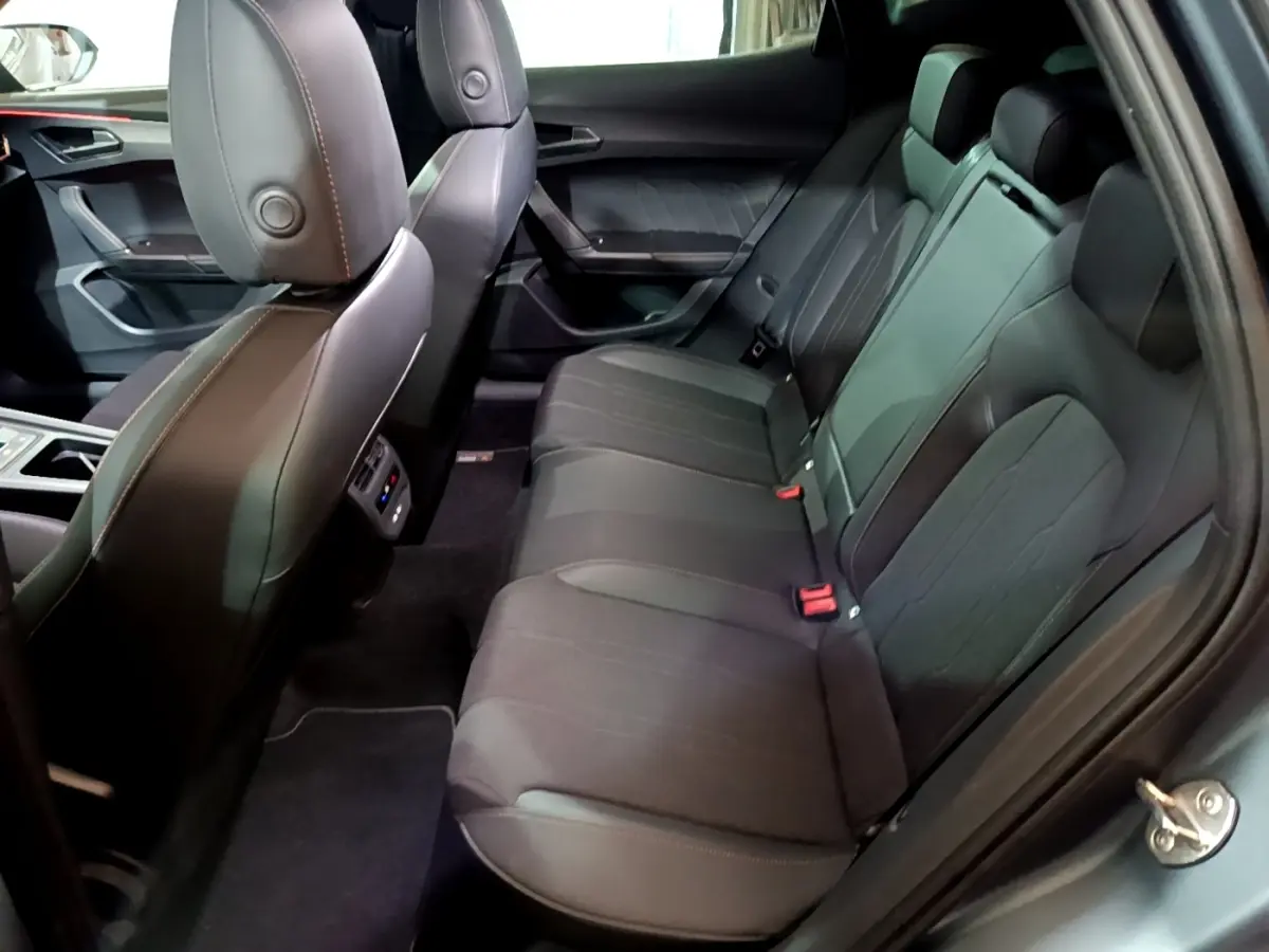 Vue latérale intérieure sur la banquette arrière noire du CUPRA Formentor 2024 avec finitions en cuir et tissu.