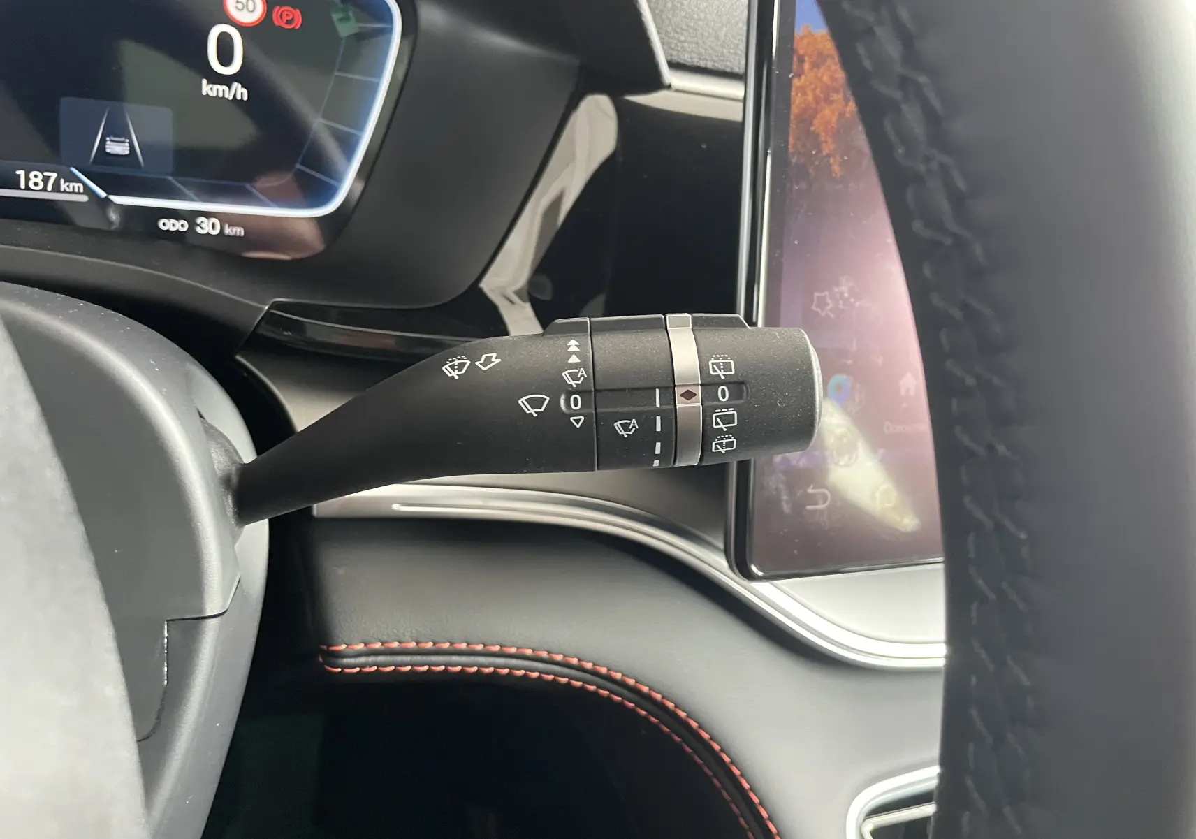 Vue rapprochée du volant noir et du tableau de bord numérique du BYD SEAL U 2026 avec commandes multifonctions et haut-parleur Infinity.