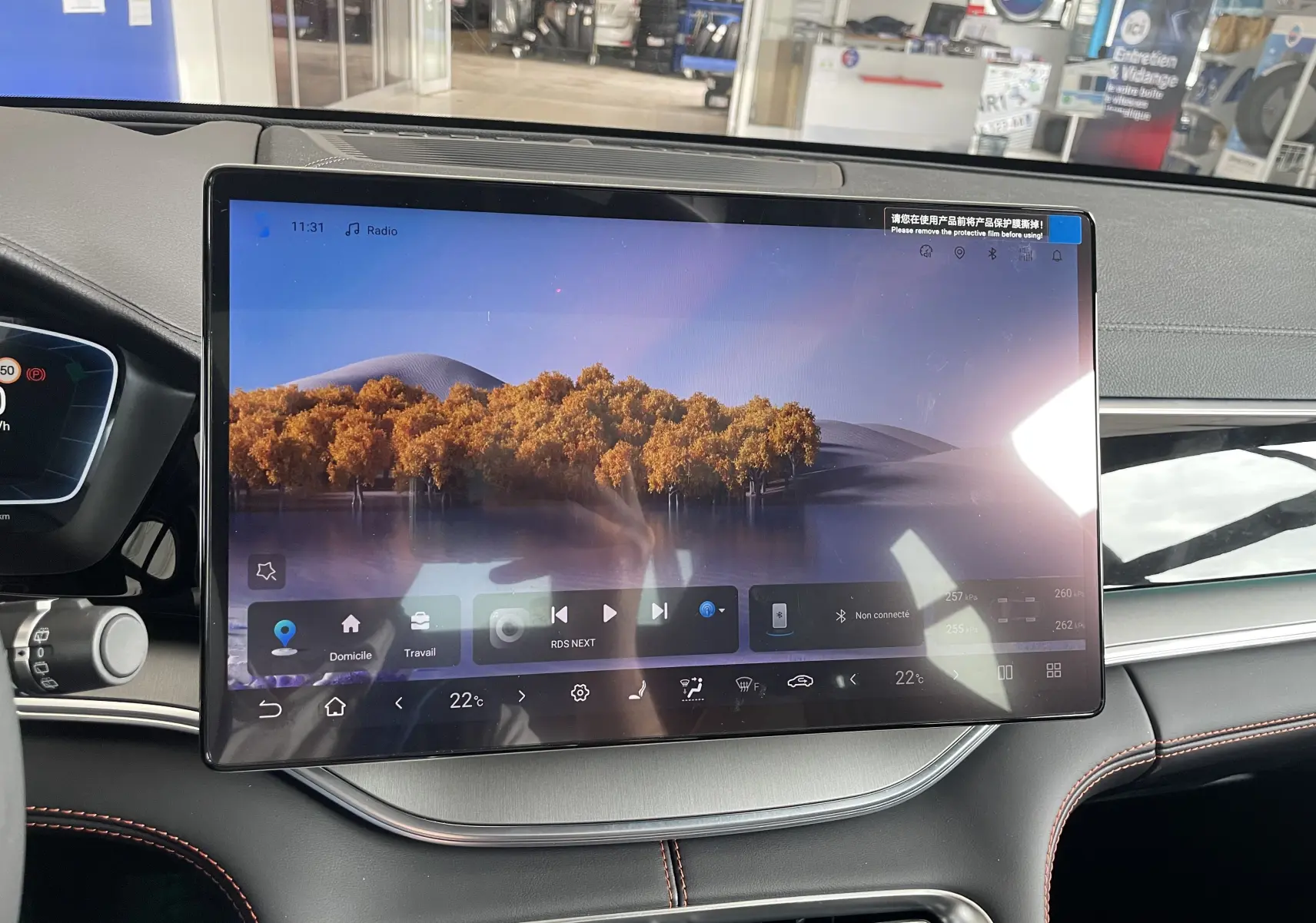 Gros plan sur la commande d’essuie-glace à gauche du volant dans l’habitacle noir avec surpiqûres rouges du BYD SEAL U TIME GREY.
