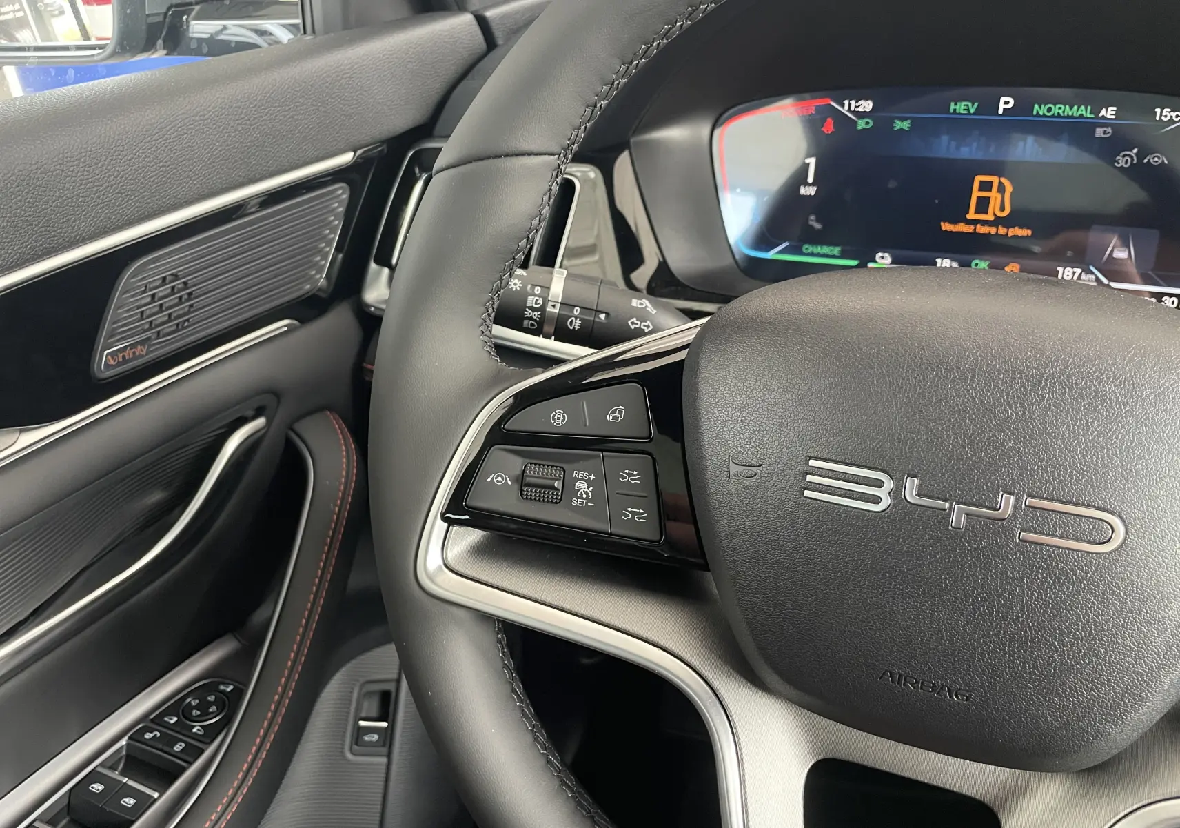 Vue intérieure frontale du tableau de bord du BYD SEAL U avec écran tactile 15,6'', volant multifonction et sièges marron.