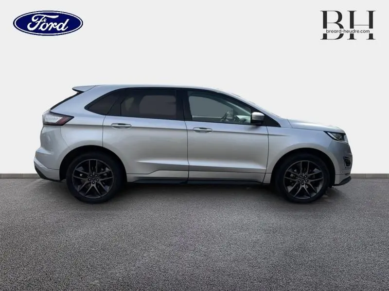 Vue de profil côté gauche du Ford Edge gris Ingot 2016 avec jantes noires et vitres teintées.