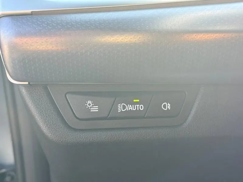 Vue rapprochée des commandes d’éclairage avec mode automatique activé sur BMW X2 Skyscraper Grey 2025.