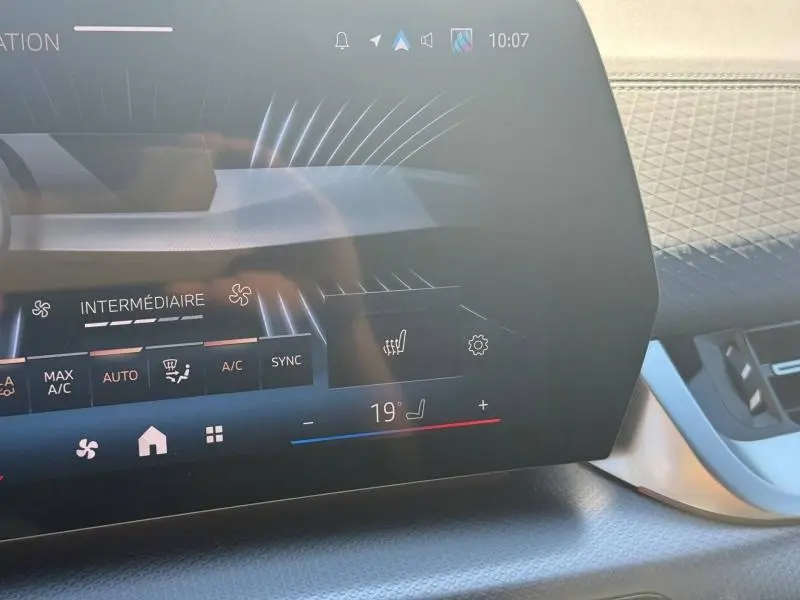 Détail de l'écran tactile central du tableau de bord du BMW X2 2025, affichant la climatisation et le réglage de siège chauffant.