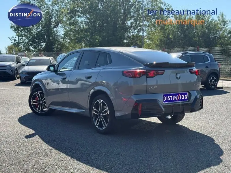 BMW X2 sDrive20dA M Sport gris Skyscraper métallisé vue 3/4 arrière droit avec jantes alu et spoiler noir.