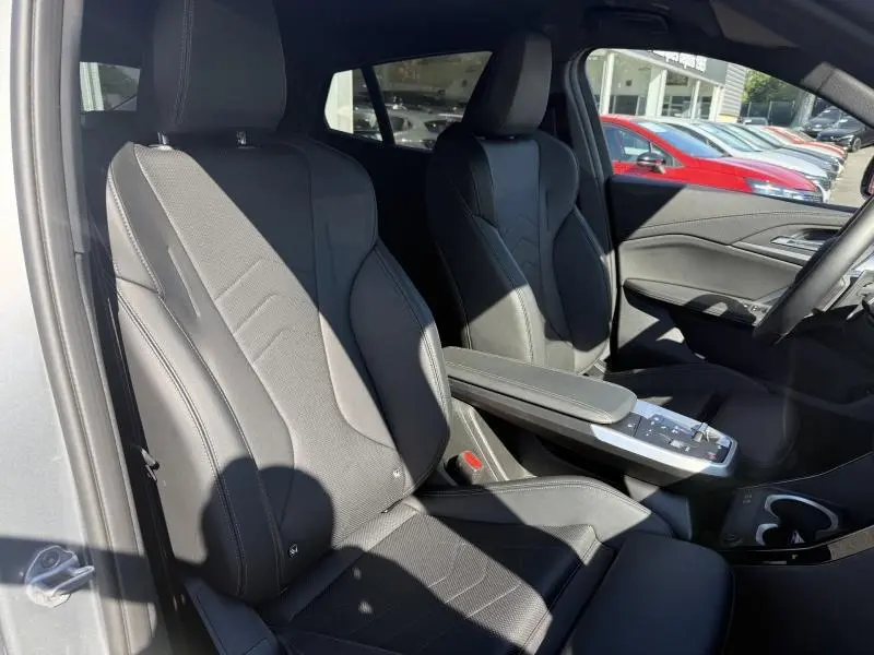 Vue intérieure côté gauche montrant les sièges avant noirs en alcantara et simili du BMW X2 Skyscraper Grey 2025.