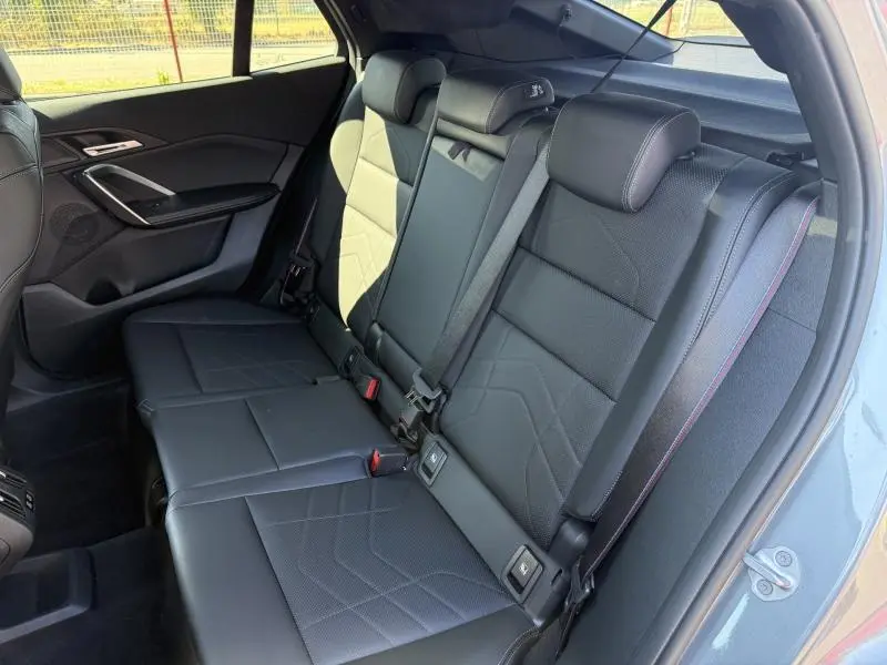Vue intérieure côté droit des sièges arrière en cuir noir avec surpiqûres contrastantes du BMW X2 Skyscraper Grey 2025.