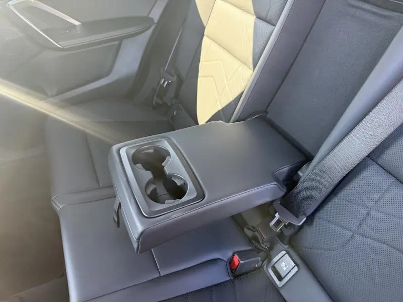 Détail de l'accoudoir central arrière avec porte-gobelets dans l'habitacle noir du BMW X2 sDrive20dA 2025.