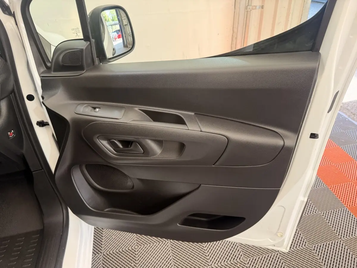 Vue rapprochée de la porte avant gauche noire du Citroën Berlingo blanc 2022, avec rétroviseur électrique.