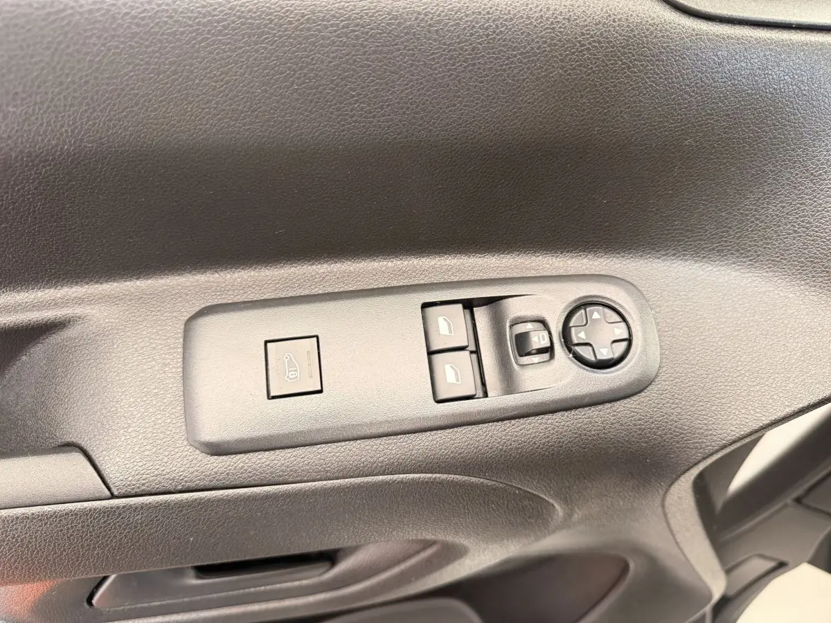 Gros plan sur les commandes de réglage des rétroviseurs et des vitres côté conducteur du Citroën Berlingo blanc 2022.