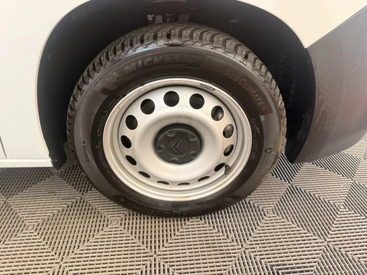 Gros plan sur la roue avant droite blanche du Citroën Berlingo 2022 avec jante acier et pneu Michelin.