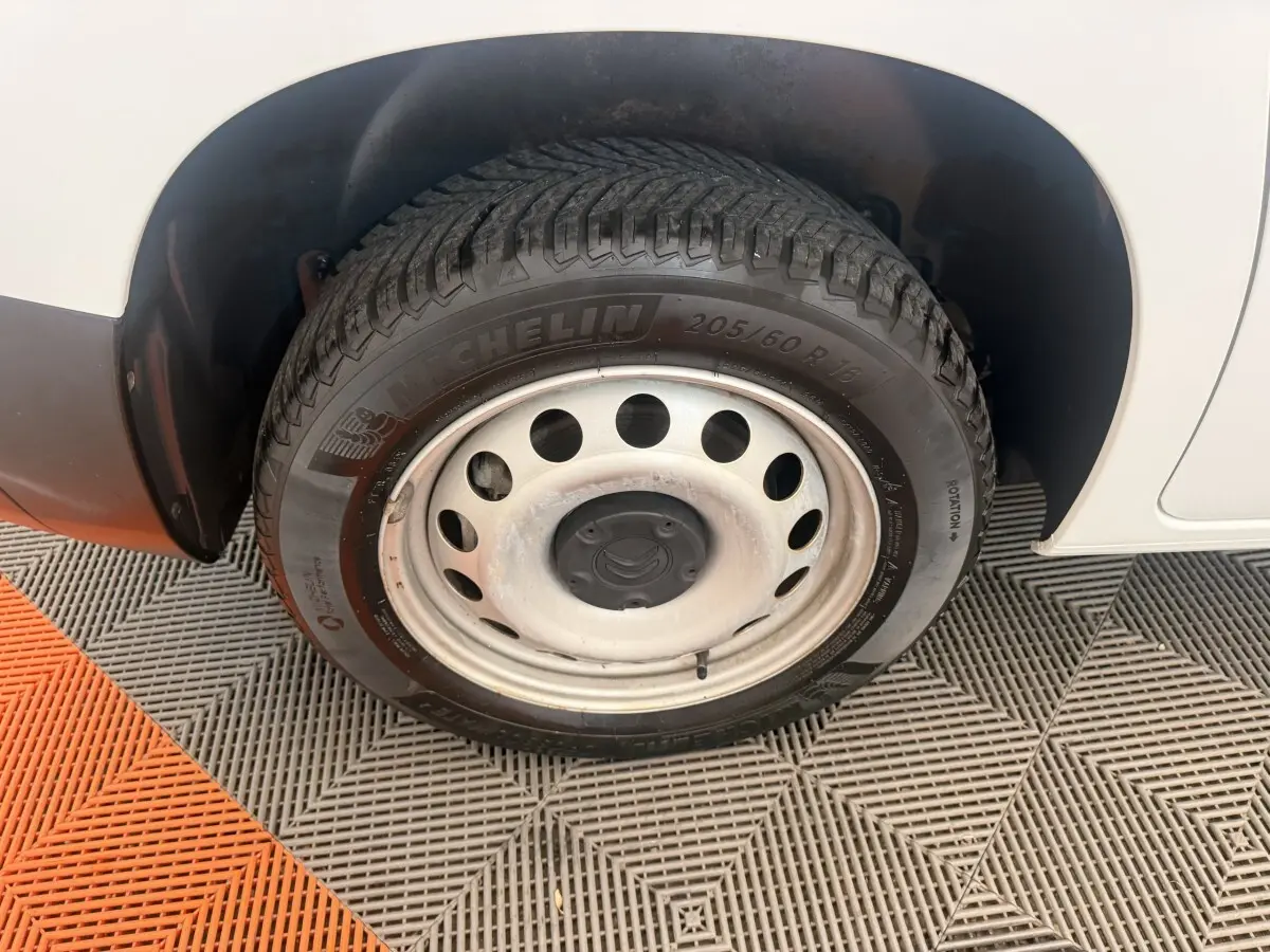Gros plan sur la roue arrière droite du Citroën Berlingo blanc avec jante acier et pneu Michelin.
