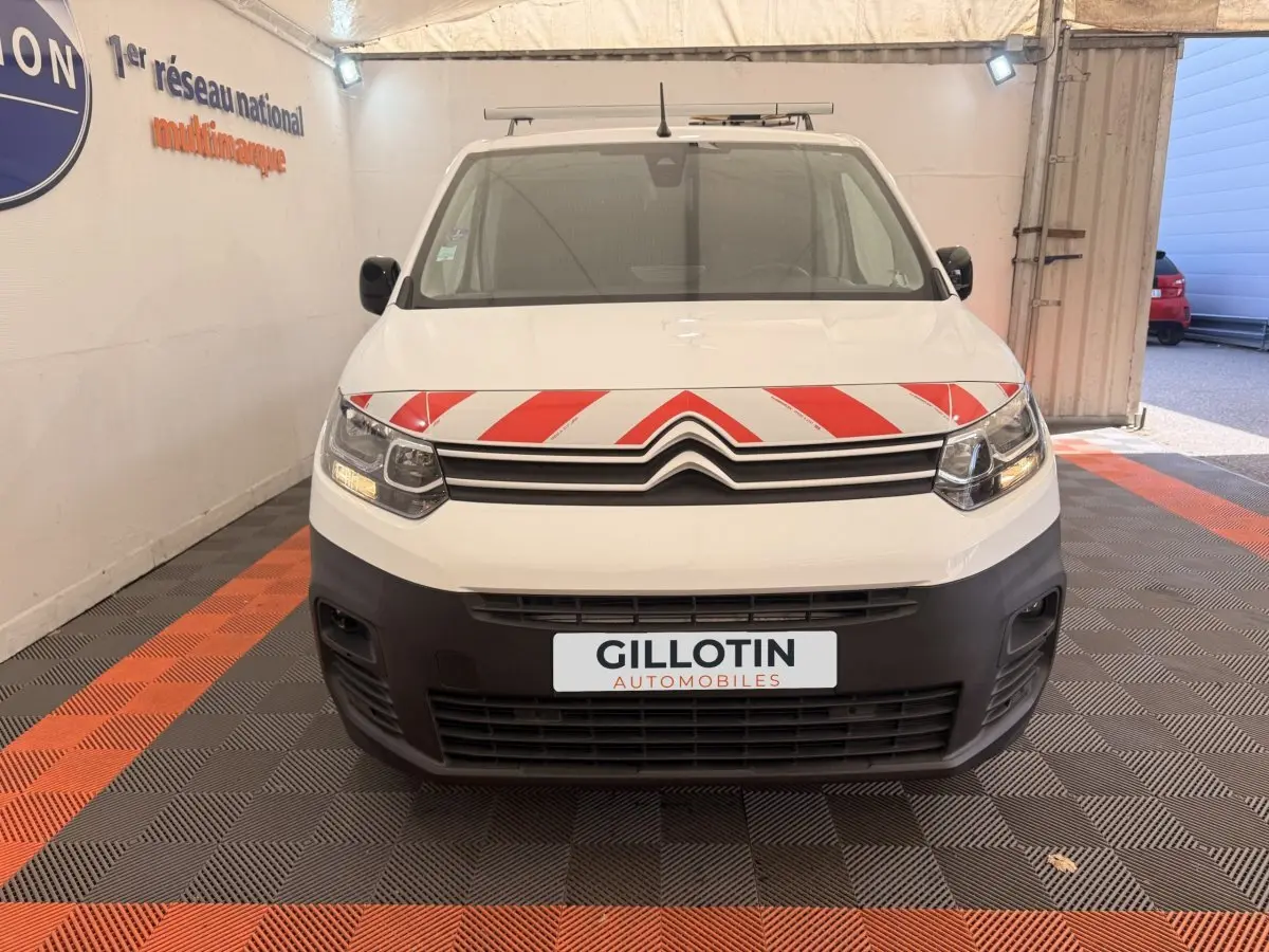 Vue de face du Citroën Berlingo blanc avec bandes rouges diagonales sur le capot et pare-chocs noir.