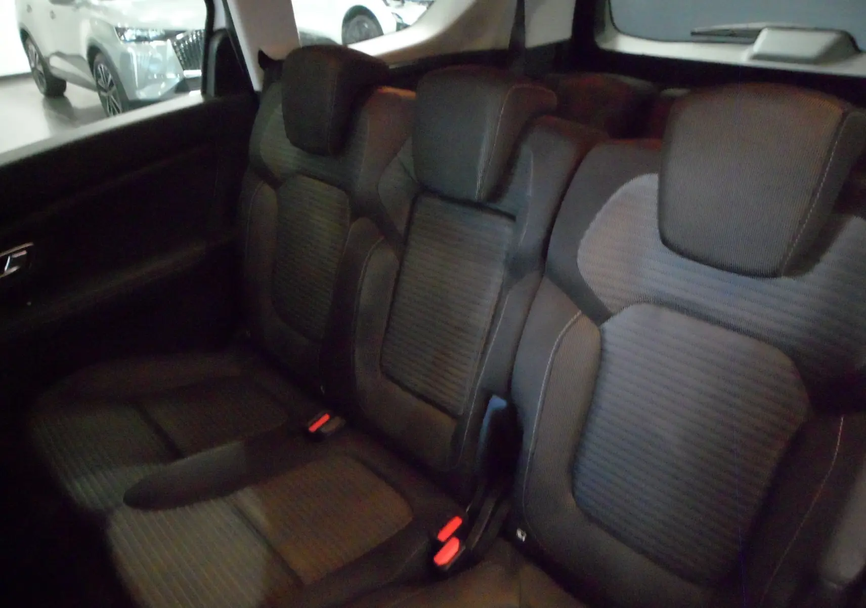 Vue intérieure des sièges arrière en tissu noir du Renault Grand Scenic IV Blue dCi 120 Business, avec appuie-têtes intégrés.