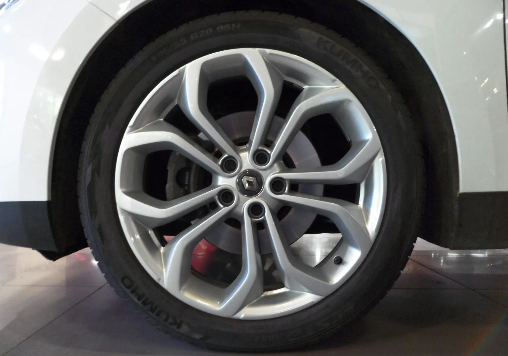 Gros plan sur la roue avant gauche blanche glacée du Renault Grand Scenic IV Blue dCi 120 CH BUSINESS avec jante alu.