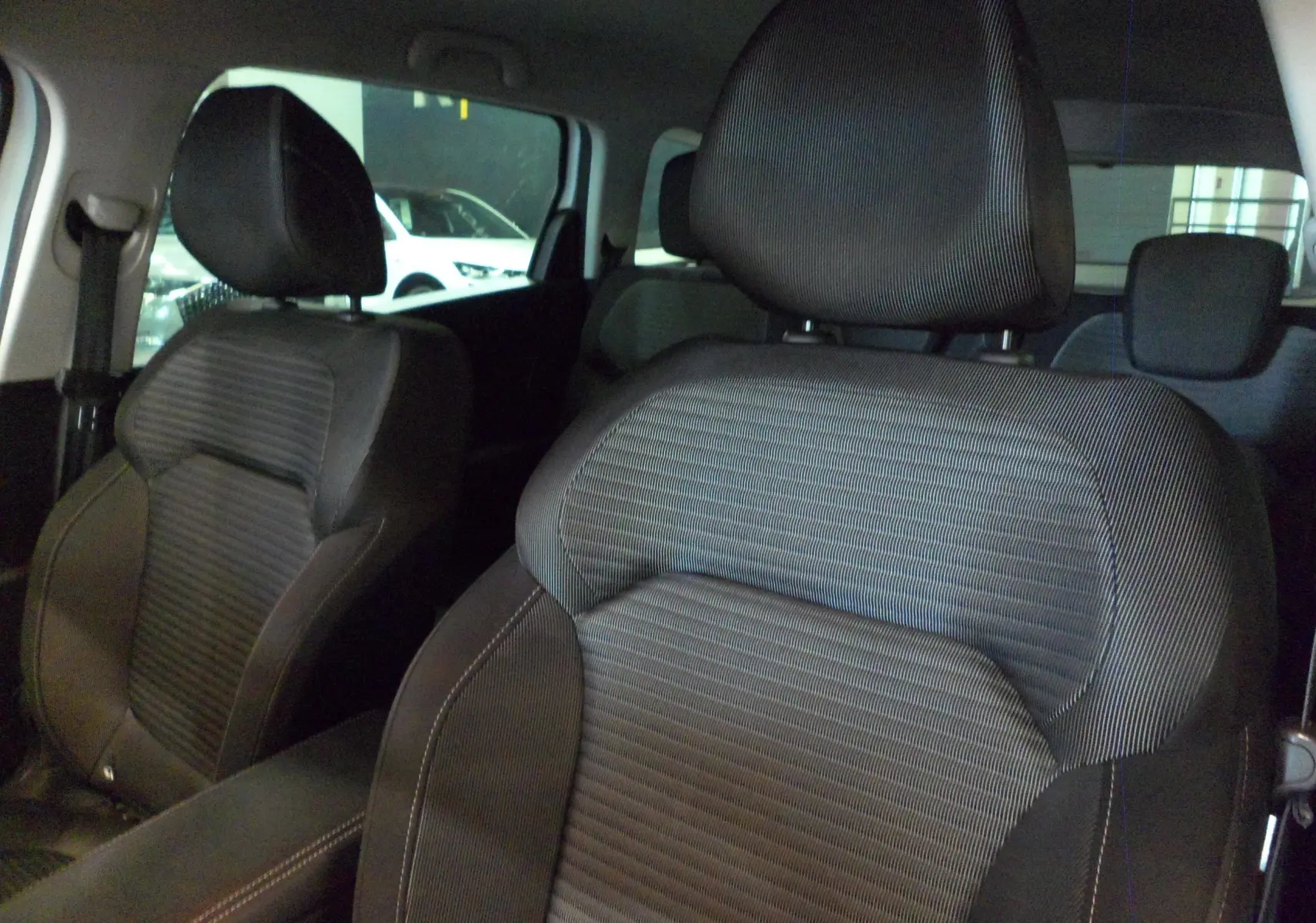 Gros plan sur les sièges avant en tissu gris foncé du Renault Grand Scenic IV 2019, intérieur spacieux et moderne.