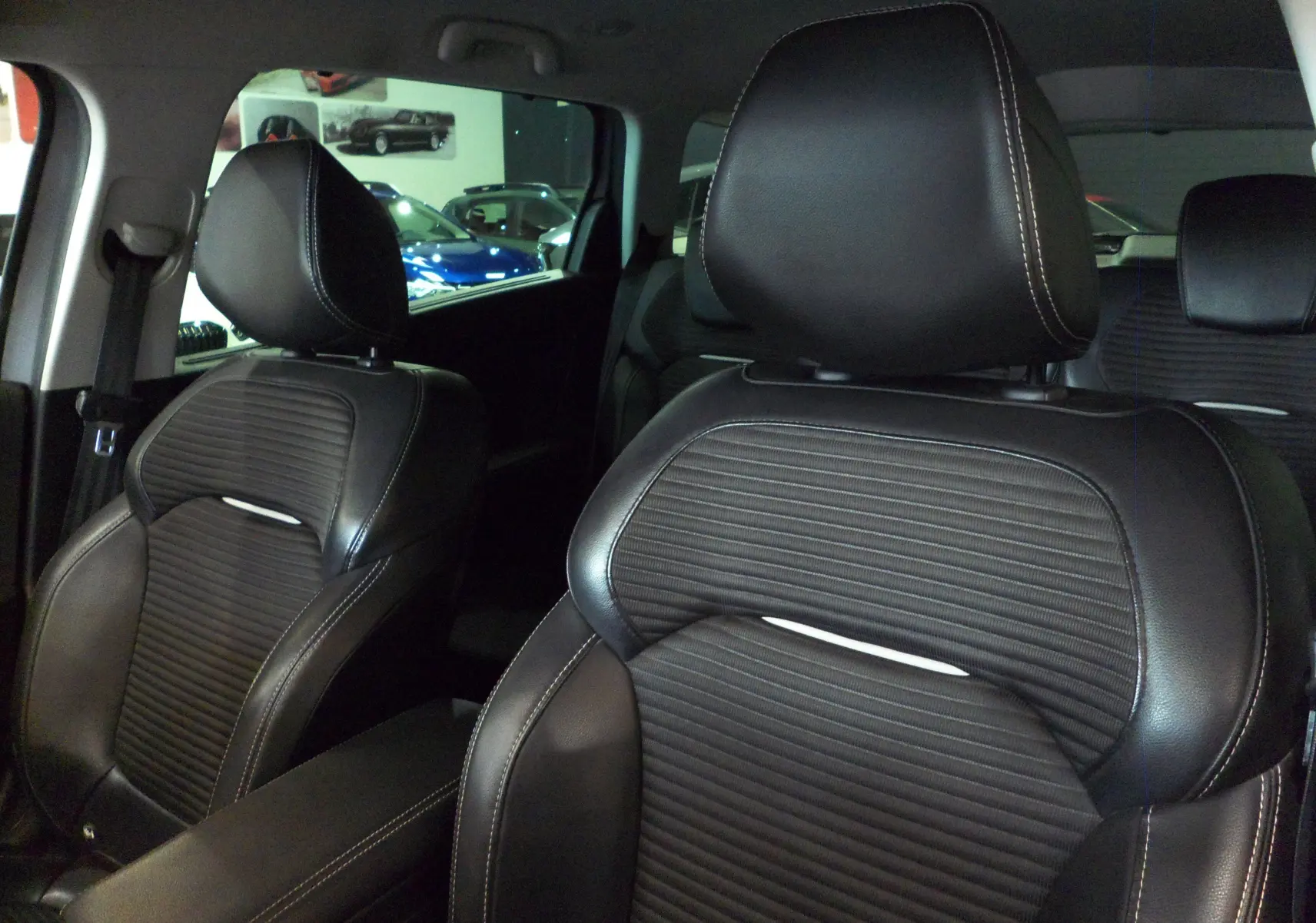 Gros plan sur les sièges avant en cuir noir avec surpiqûres blanches du Renault Grand Scenic IV 2020.