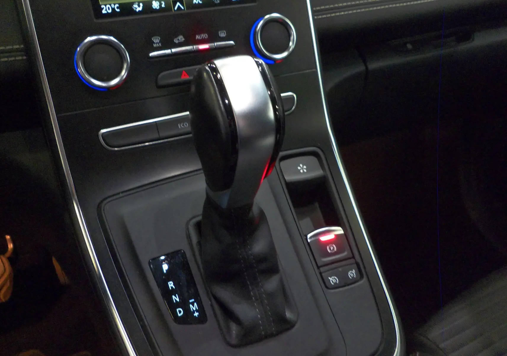 Le levier de vitesses automatique noir et argenté du Renault Grand Scenic IV, avec commandes climatisation en arrière-plan.