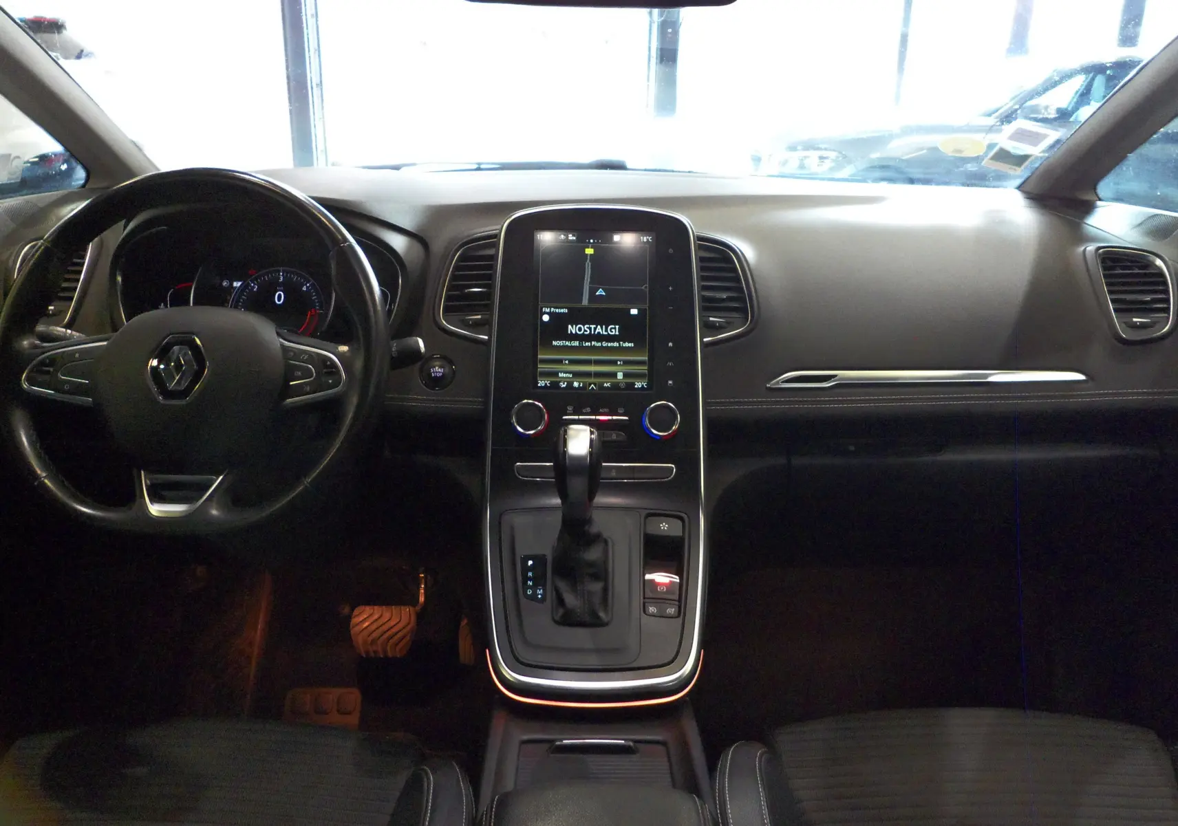Vue intérieure du tableau de bord et console centrale du Renault Grand Scenic IV avec écran tactile et volant noir.