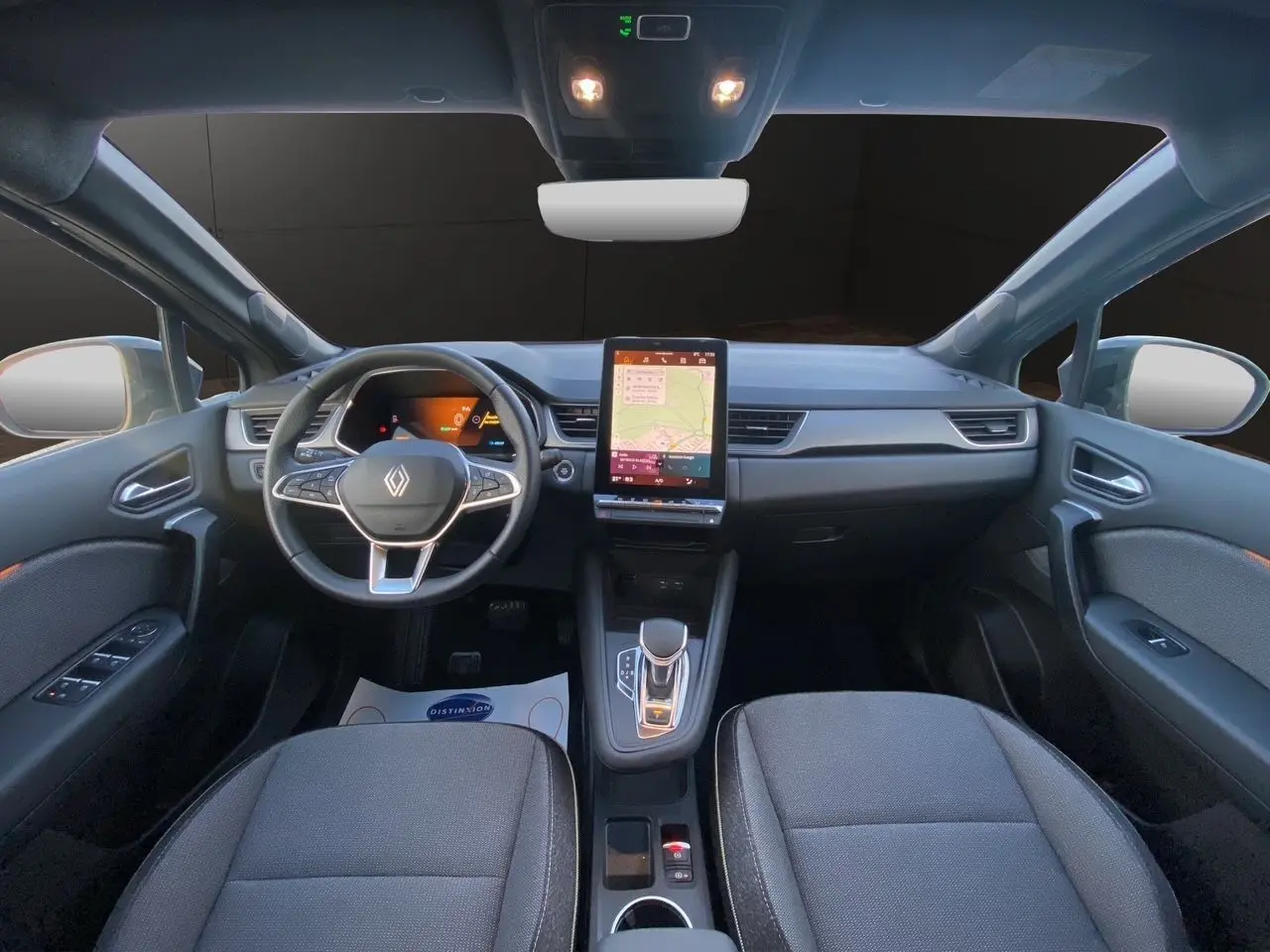 Vue intérieure avant du Renault Symbioz E-Tech Full Hybrid 145 Techno, avec tableau de bord numérique et écran tactile central vertical.