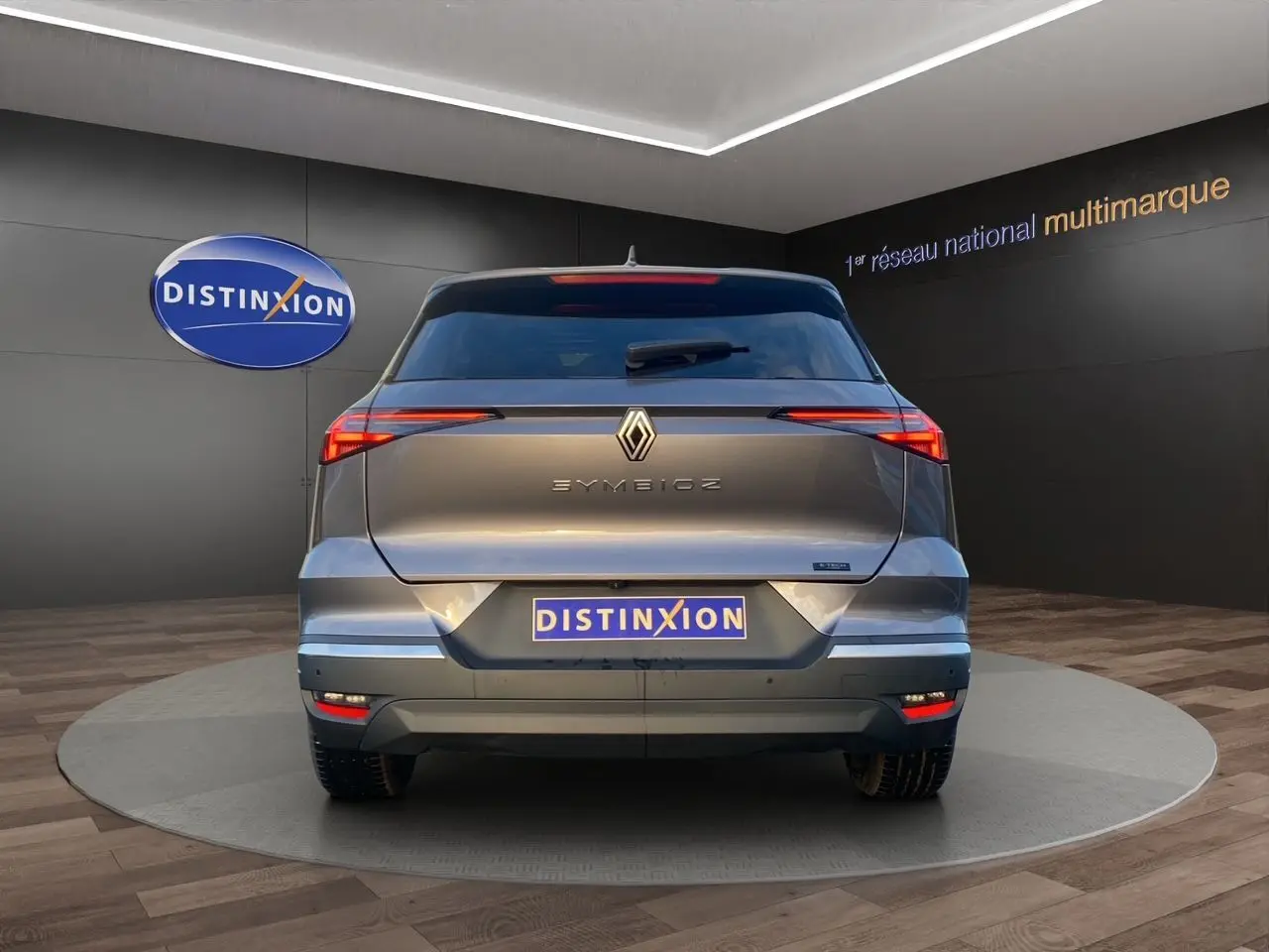 Vue arrière d'une Renault SYMBIOZ gris Casiopee avec feux arrière fins et logo centré dans un showroom.
