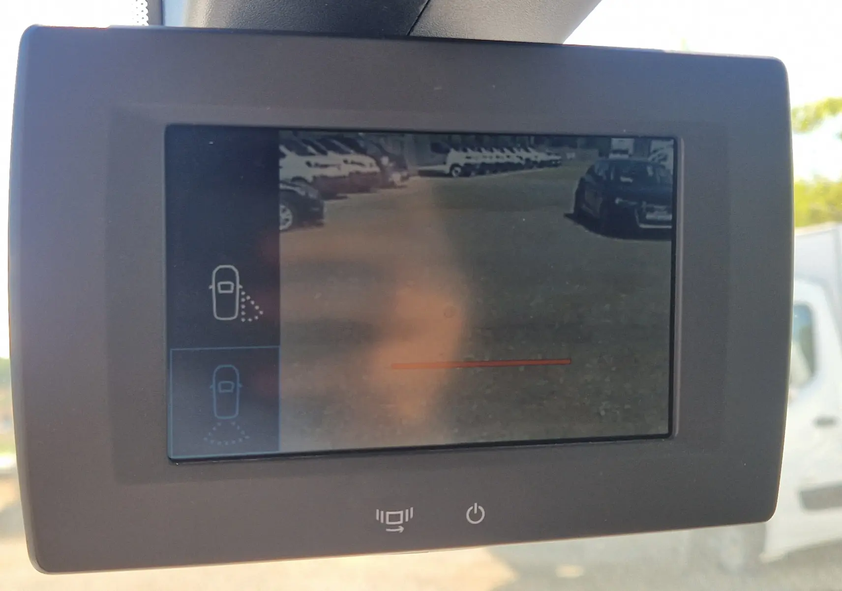 Écran de caméra de recul affichant une vue arrière du parking, dans un Citroën Berlingo blanc de 2020.