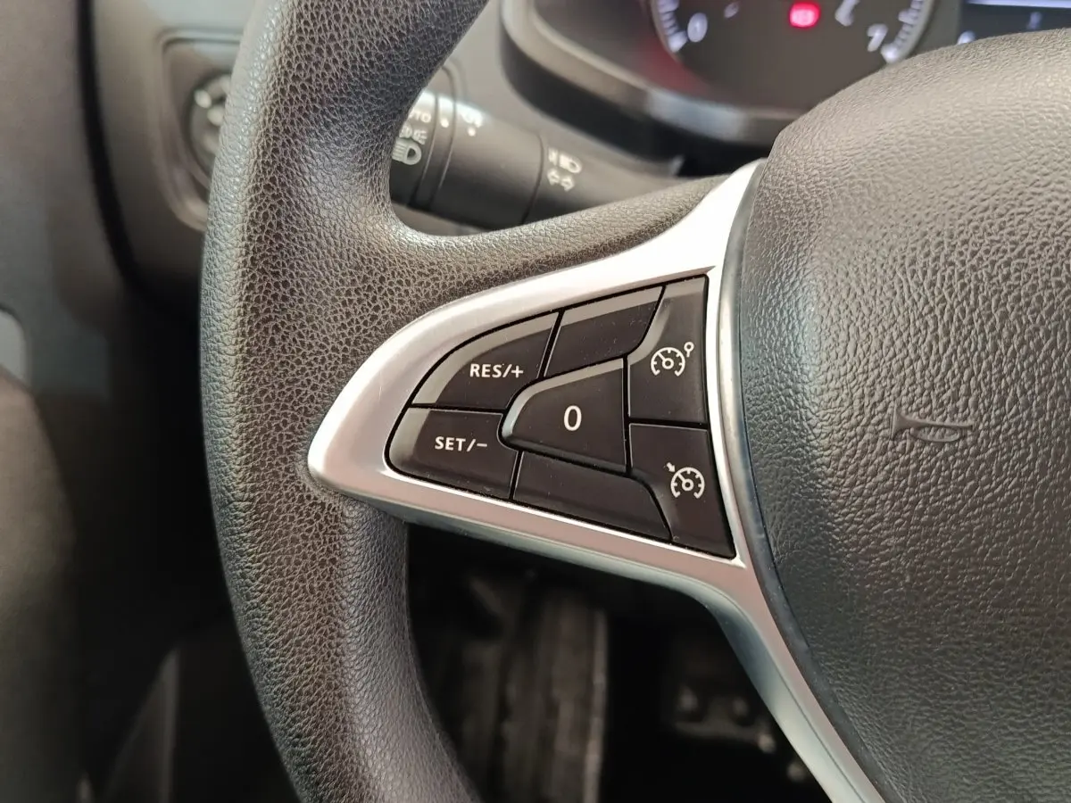 Gros plan sur le volant noir multifonctions du Renault Express 2023, avec commandes de régulateur de vitesse.