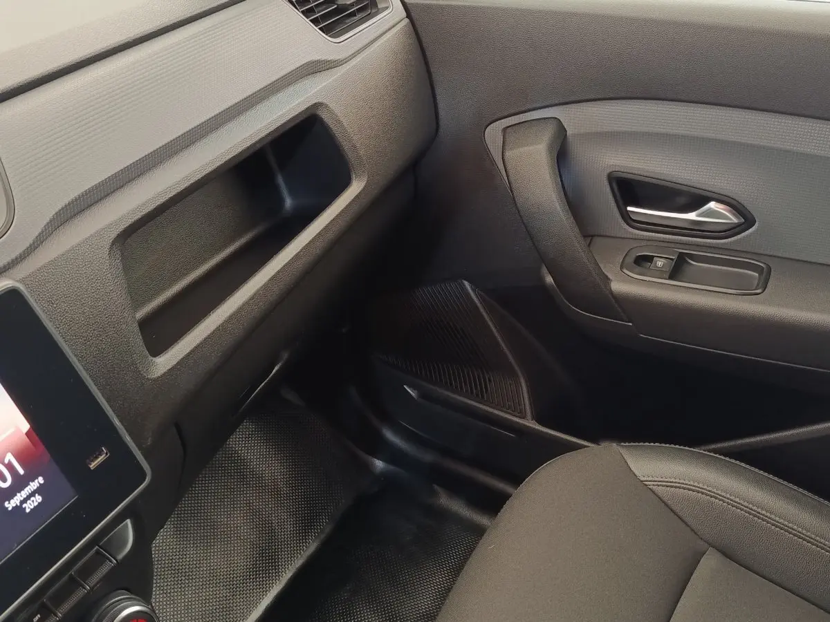 Vue intérieure côté passager avant du Renault Express 2023, montrant la porte, la console et le siège noir.