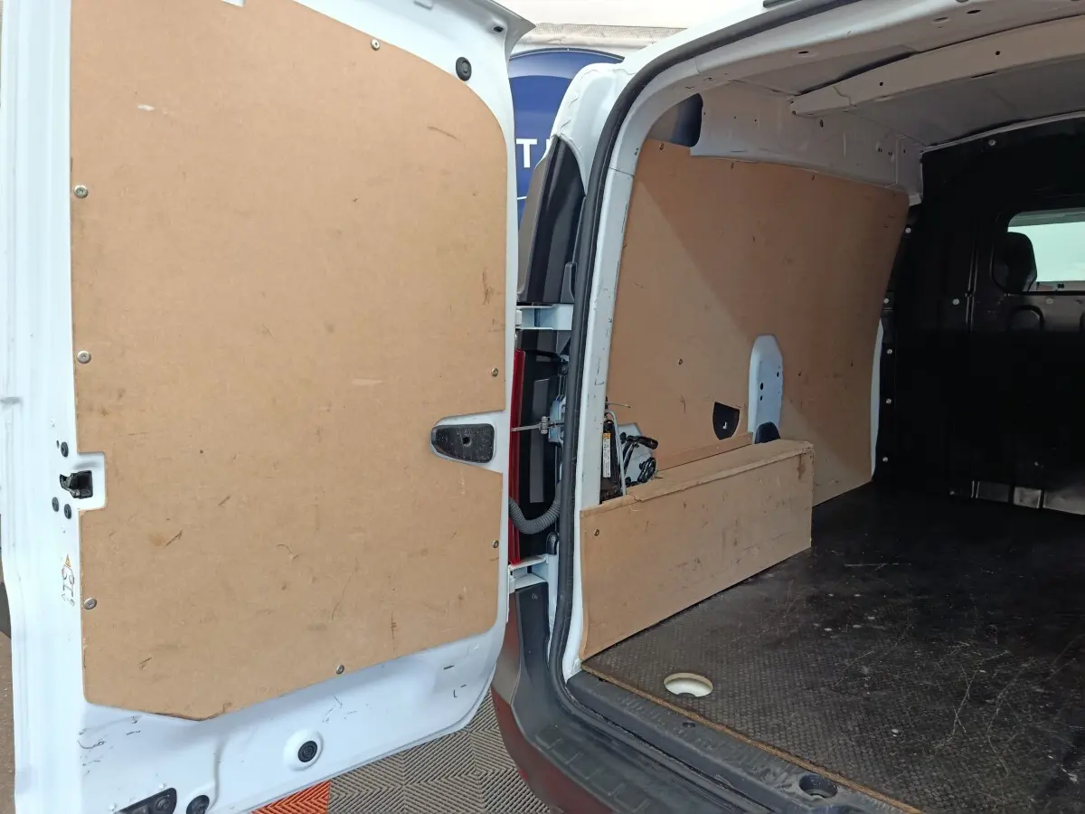 Vue intérieure arrière du Renault Express blanc 2023, montrant l'espace de chargement avec cloison pleine en bois.