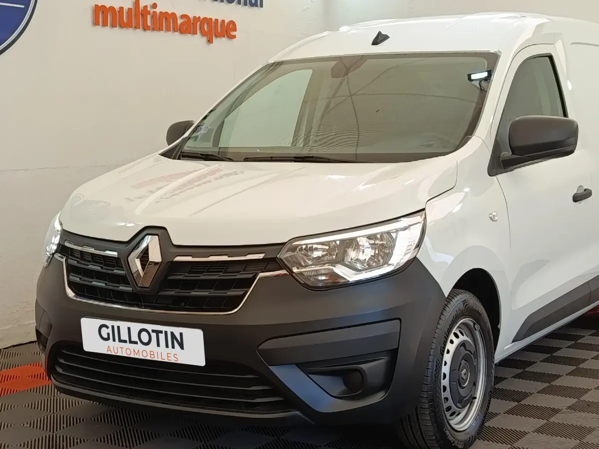 Vue 3/4 avant droite du Renault Express blanc avec calandre noire et jantes acier, en intérieur showroom.