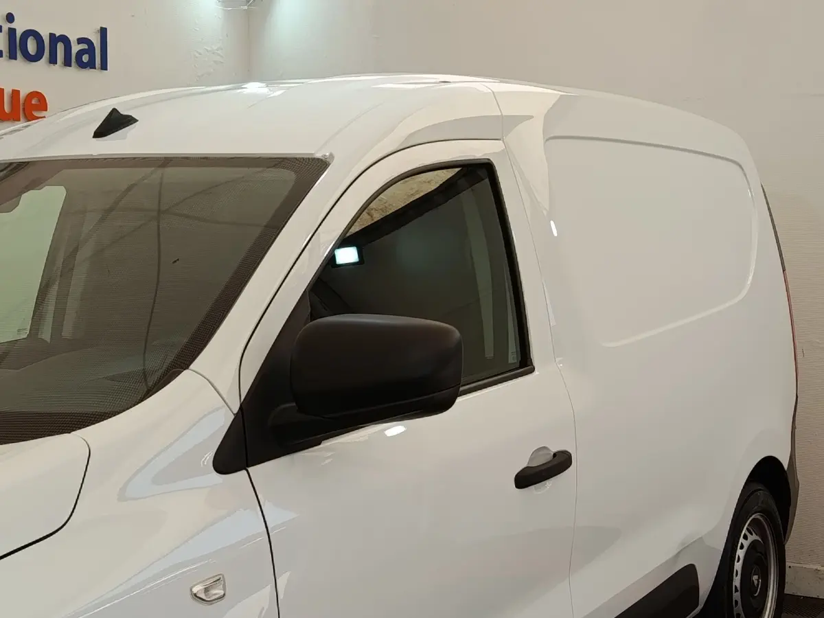 Vue de profil côté gauche d’un utilitaire Renault Express blanc avec porte latérale pleine et rétroviseur noir.