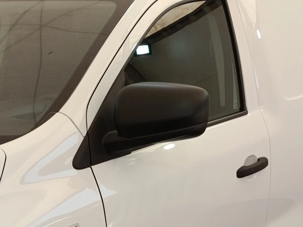 Vue rapprochée du côté gauche d’un Renault Express blanc, mettant en valeur la portière et le rétroviseur noir.