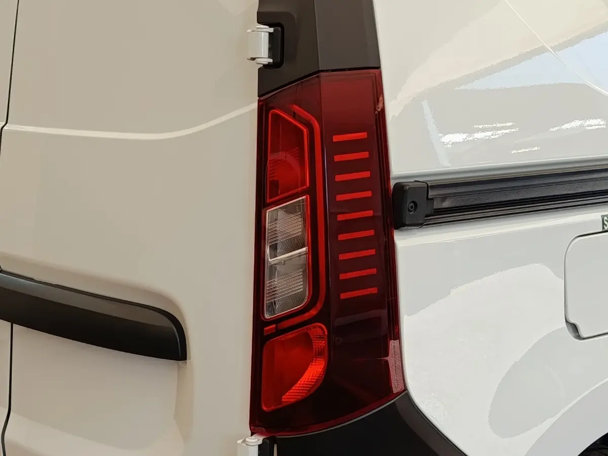 Gros plan sur le feu arrière droit rouge du Renault Express blanc, avec partie de la porte arrière visible.