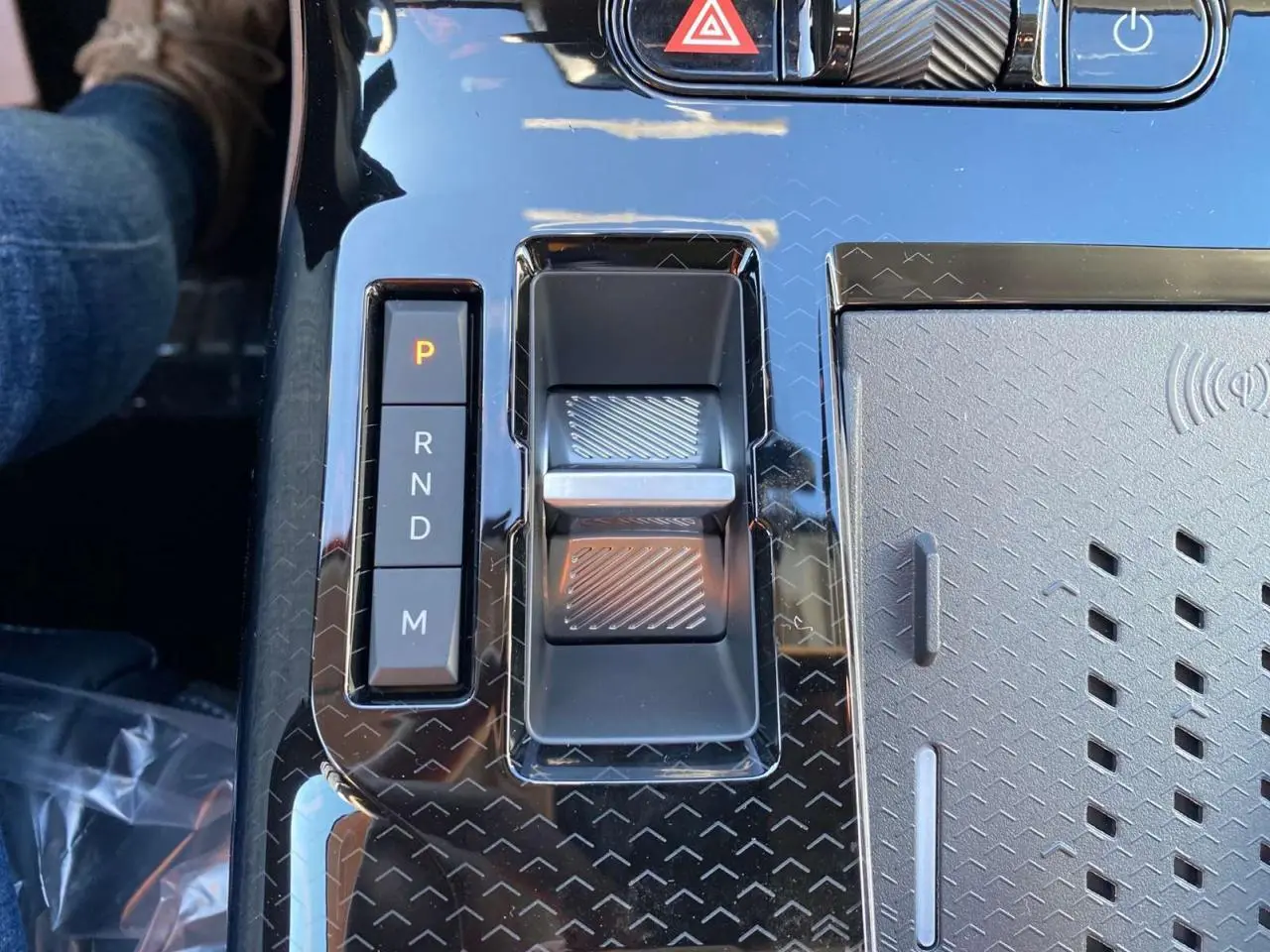 Gros plan sur la console centrale noire brillante du Citroën C5 Aircross avec sélecteur de vitesses électronique et zone de recharge sans fil.