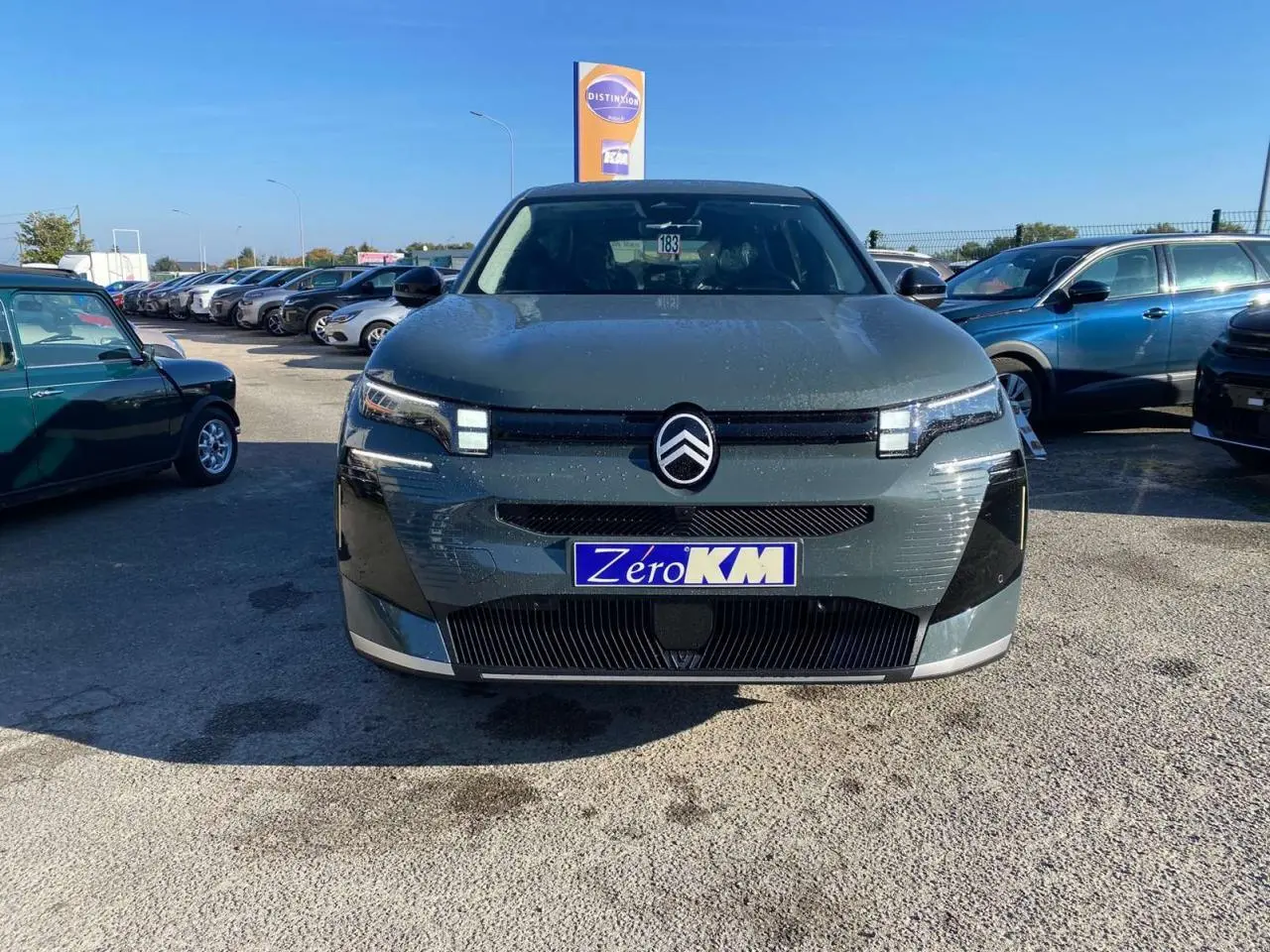 Vue frontale d'une Citroën C5 Aircross hybride 2026 vert métallisé avec calandre distinctive et logo central.