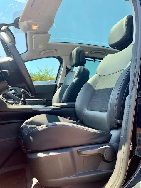 Intérieur du Peugeot 3008 2014 noir, vue côté conducteur montrant les sièges avant en cuir et le toit ouvrant.