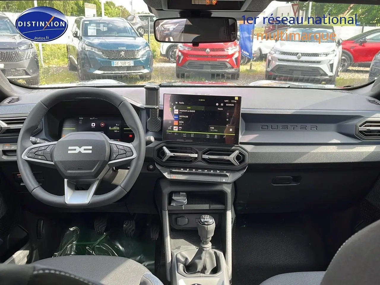 Vue intérieure avant du Dacia Duster 1.0 eco-g 100 Journey 2025, tableau de bord gris avec écran tactile et volant multifonction.