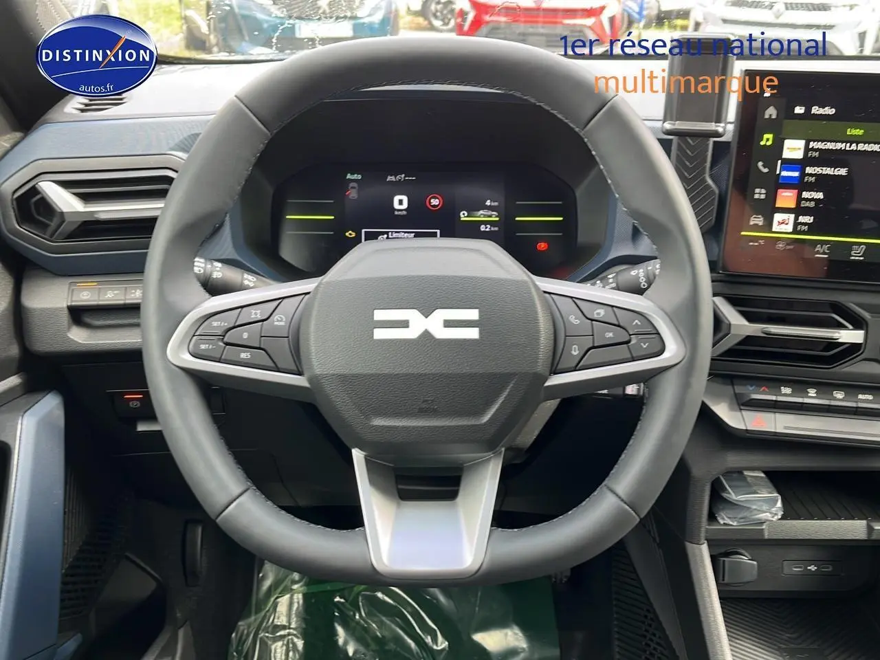 Vue frontale du volant multifonction et tableau de bord numérique du Dacia Duster 2025, intérieur noir moderne.