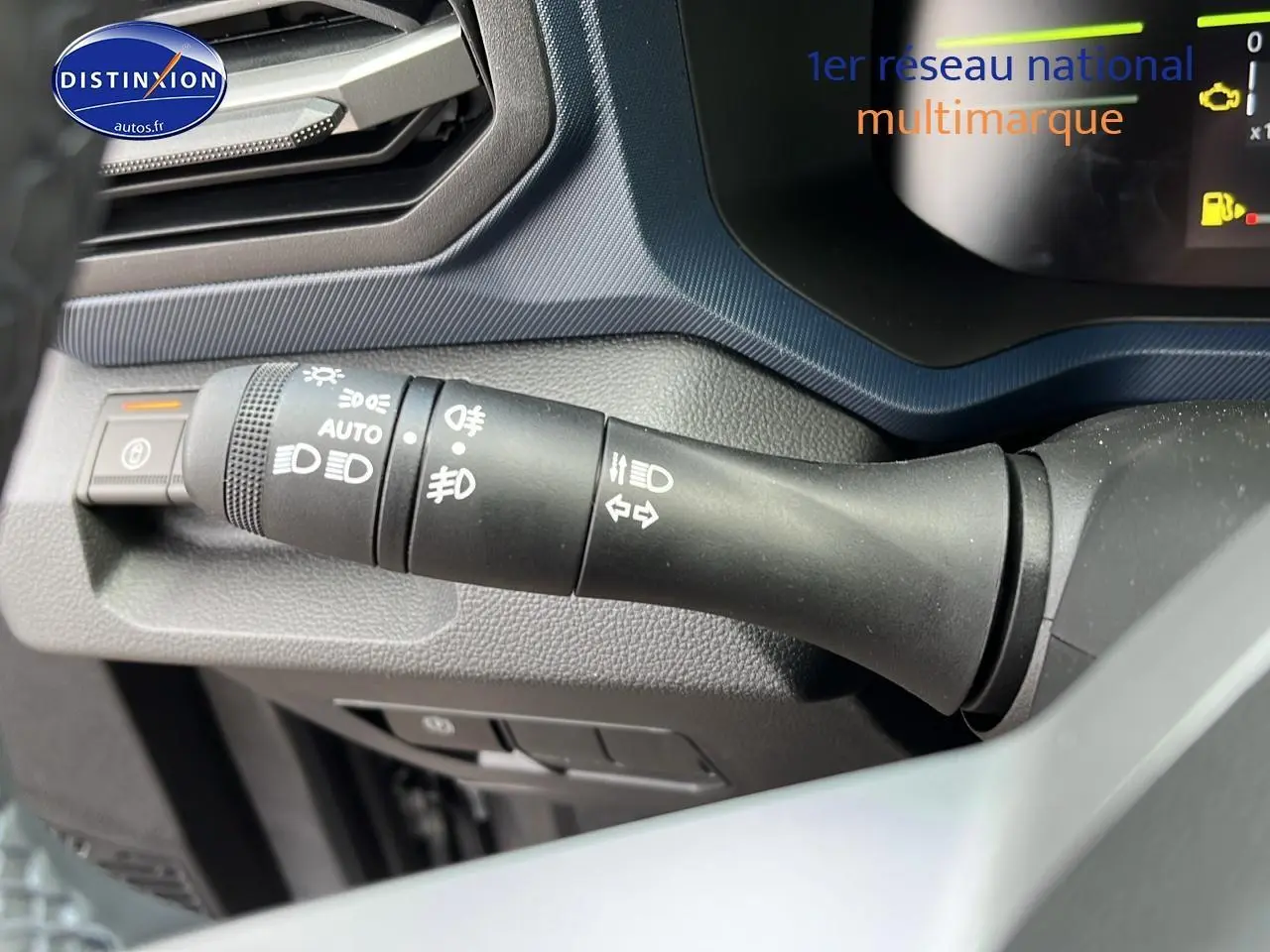 Gros plan sur la commande des feux et clignotants du tableau de bord du Dacia Duster gris schiste 2025.