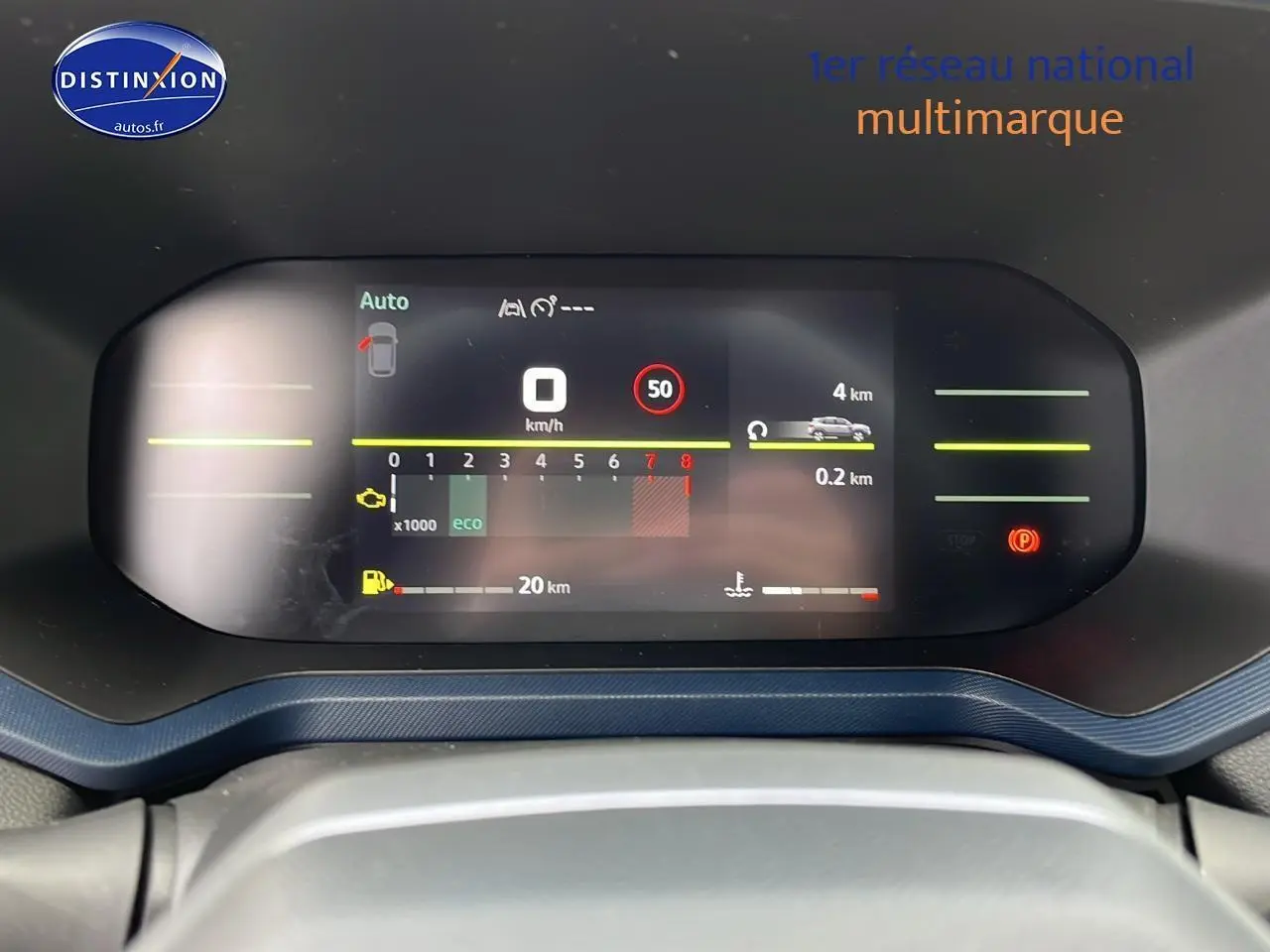 Tableau de bord numérique du Dacia Duster 2025, affichage multifonction avec fond bleu denim visible autour.