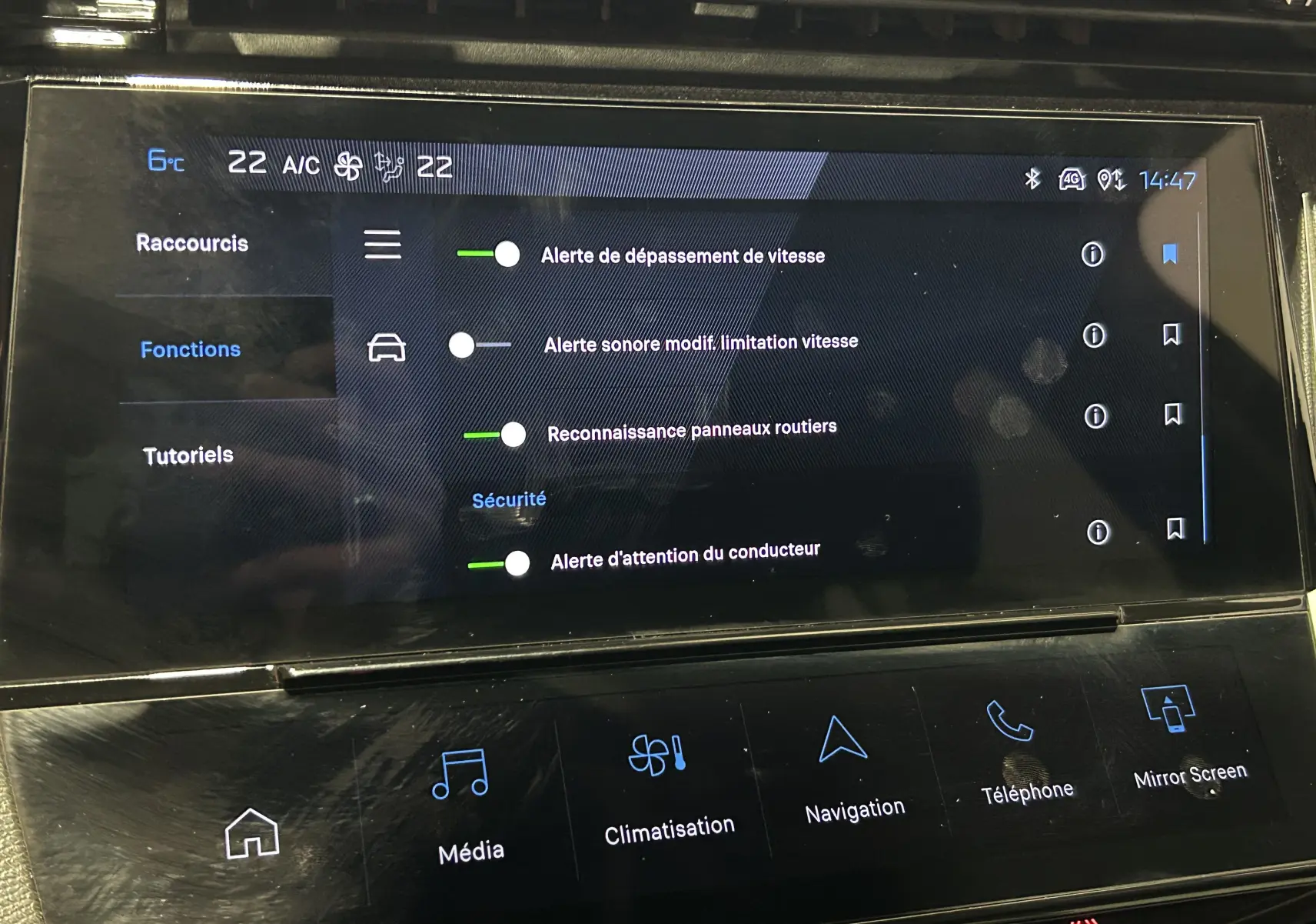 Écran tactile intérieur de la Peugeot 308 2024 montrant les réglages d’alerte de sécurité et la climatisation.