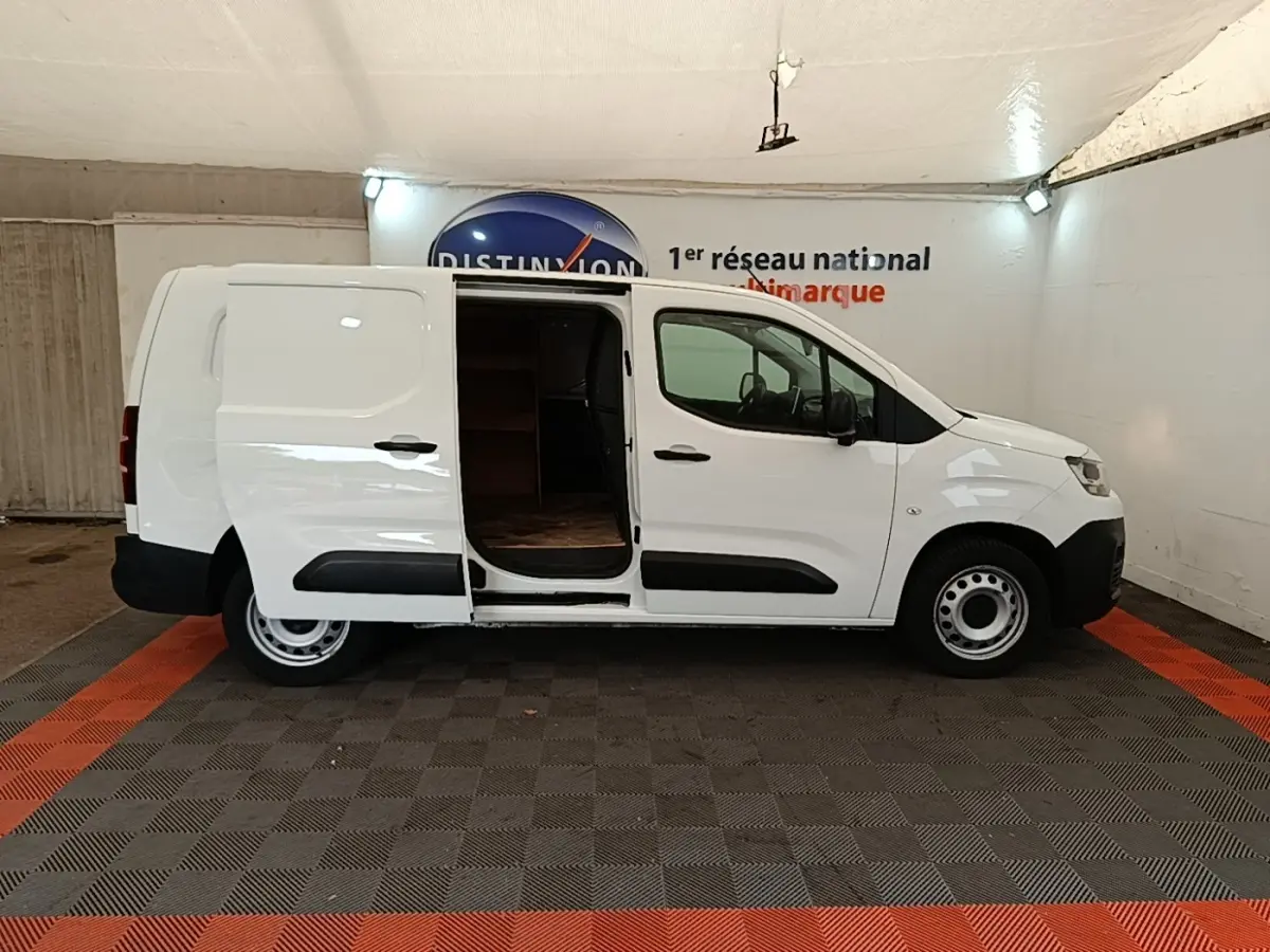 Vue de profil côté droit d’un Citroën Berlingo XL blanc 2020 avec porte latérale coulissante ouverte montrant l’intérieur vide.
